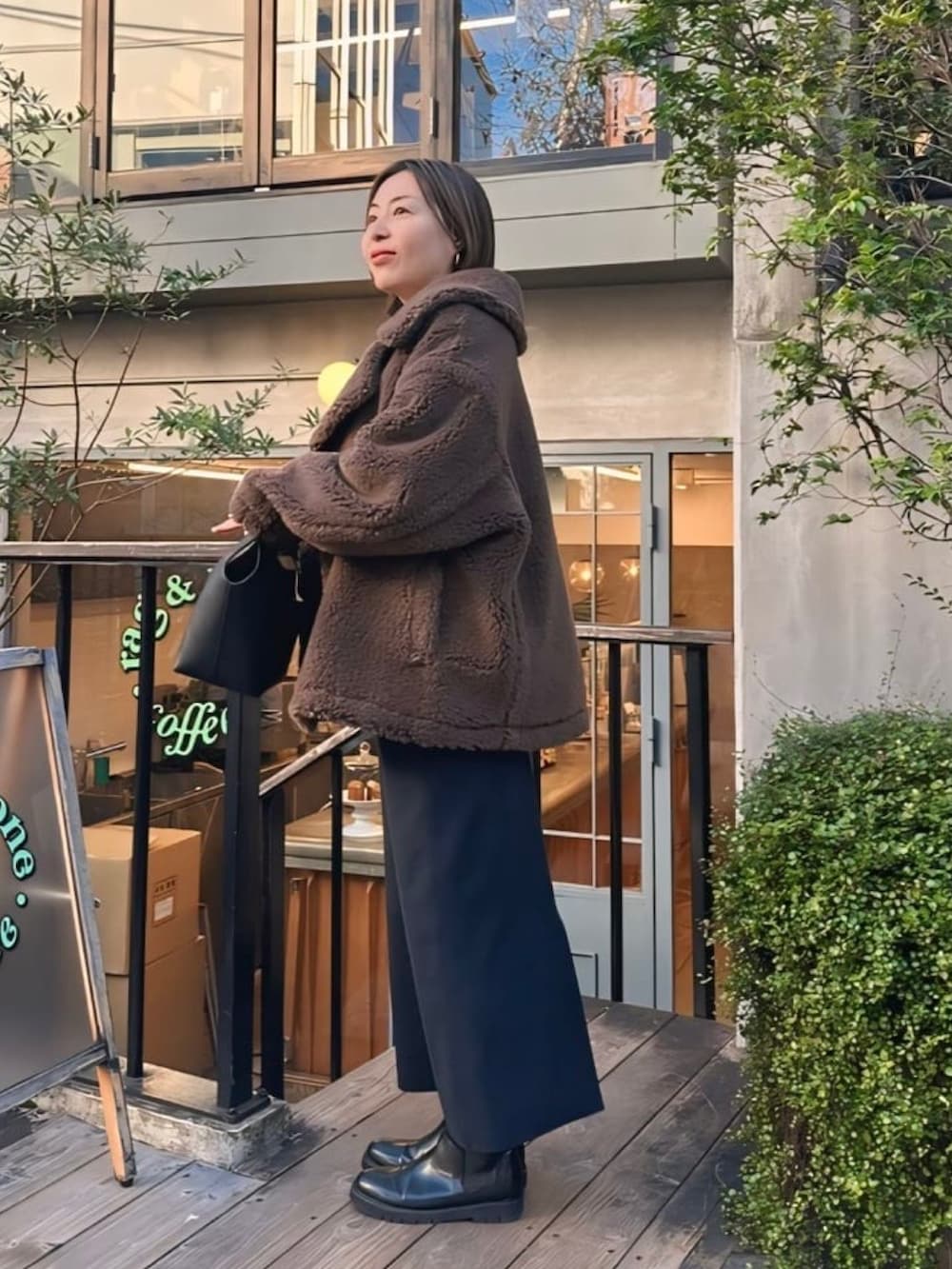 ブラウン系のその他アウター、ブルー系のスカート、ブルー系のニット/セーターを着用したレディースの秋コーディネートの2枚目の写真