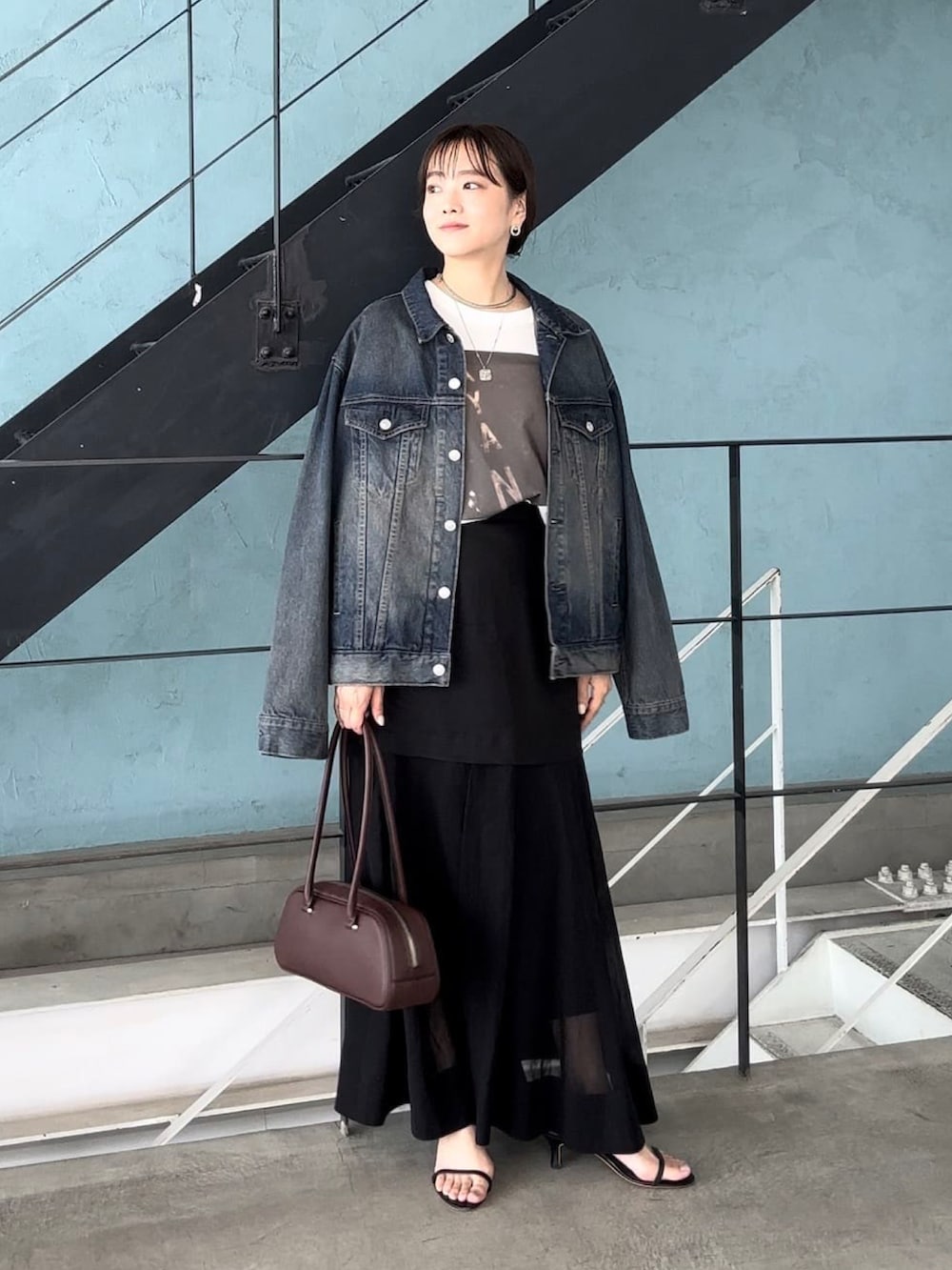 ブラウン系のTシャツ/カットソー、ブルー系のデニムジャケット、ブラック系のスカートを着用したレディースの夏コーディネートの2枚目の写真