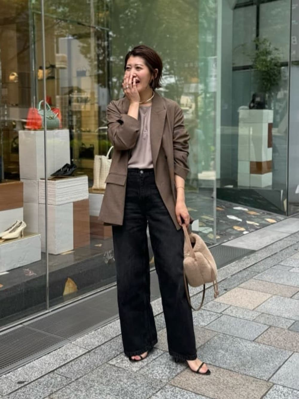 ブラック系のデニムパンツ、ベージュ系のハンドバッグ、ブラック系のサンダルを着用したレディースの夏コーディネートの2枚目の写真