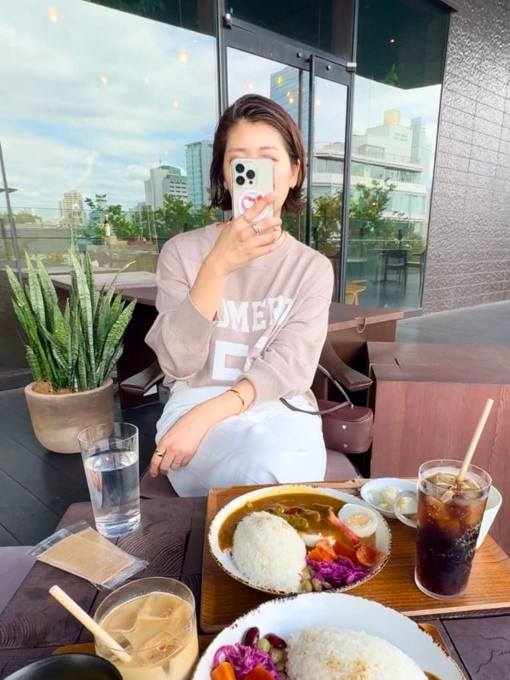 ベージュ系のニット/セーター、ホワイト系のデニムパンツ、ブラウン系のローファーを着用したレディースの秋コーディネートの4枚目の写真