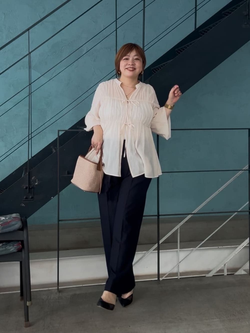 ホワイト系のシャツ/ブラウス、ブラウン系のハンドバッグ、ブルー系のチノパンツを着用したレディースの春コーディネートの2枚目の写真