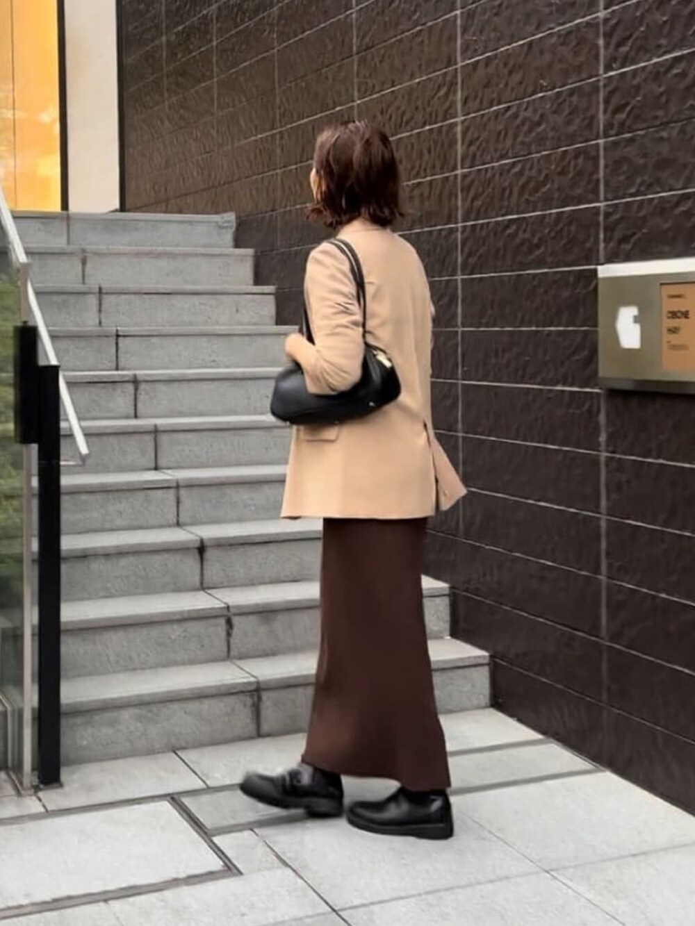 ブラウン系のワンピース、イエロー系のテーラードジャケット、ブラック系のショルダーバッグを着用したレディースの秋コーディネートの4枚目の写真