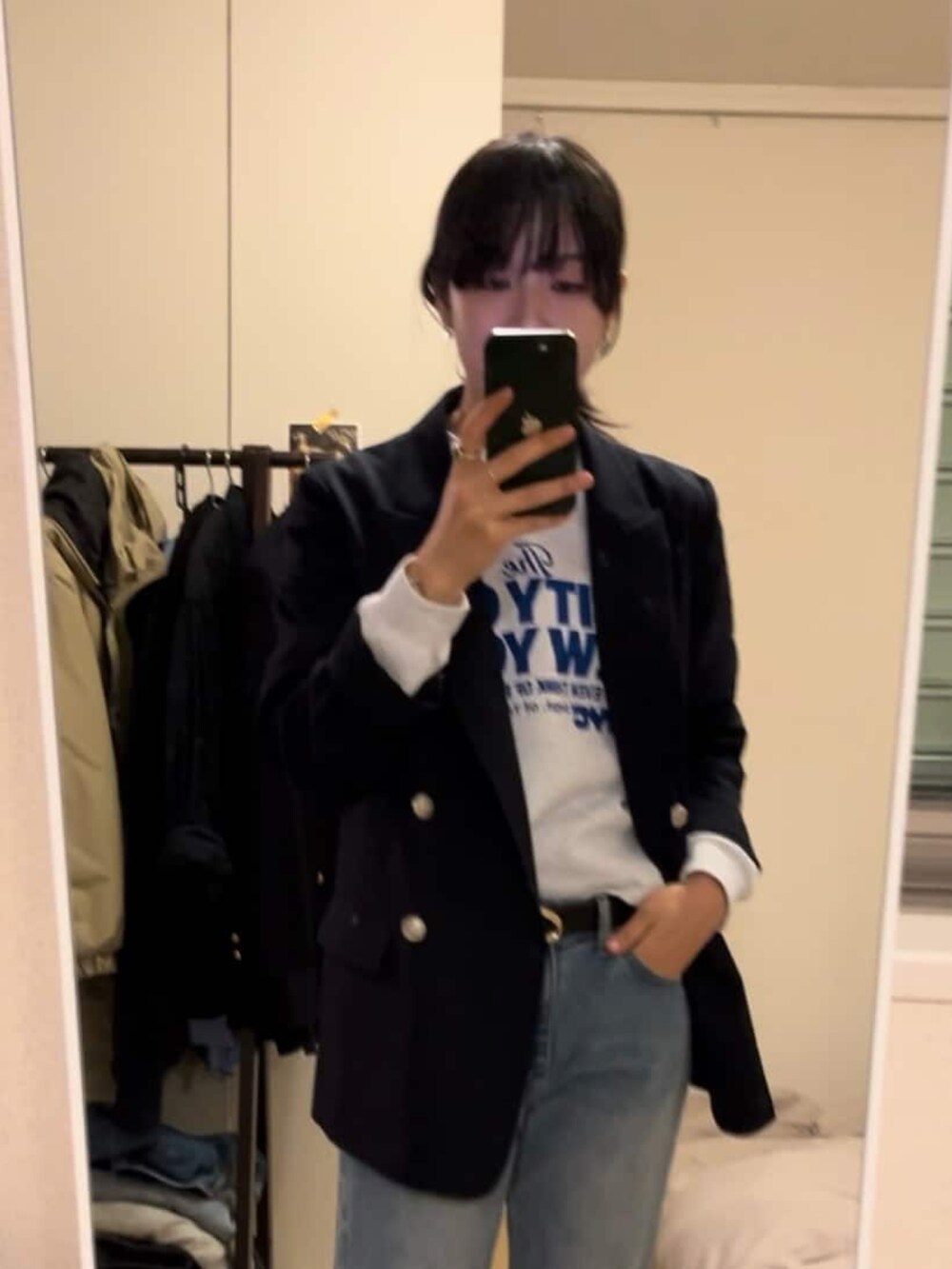 グレー系のスウェット、ブルー系のデニムパンツ、ベージュ系のテーラードジャケットを着用したレディースの冬コーディネートの3枚目の写真