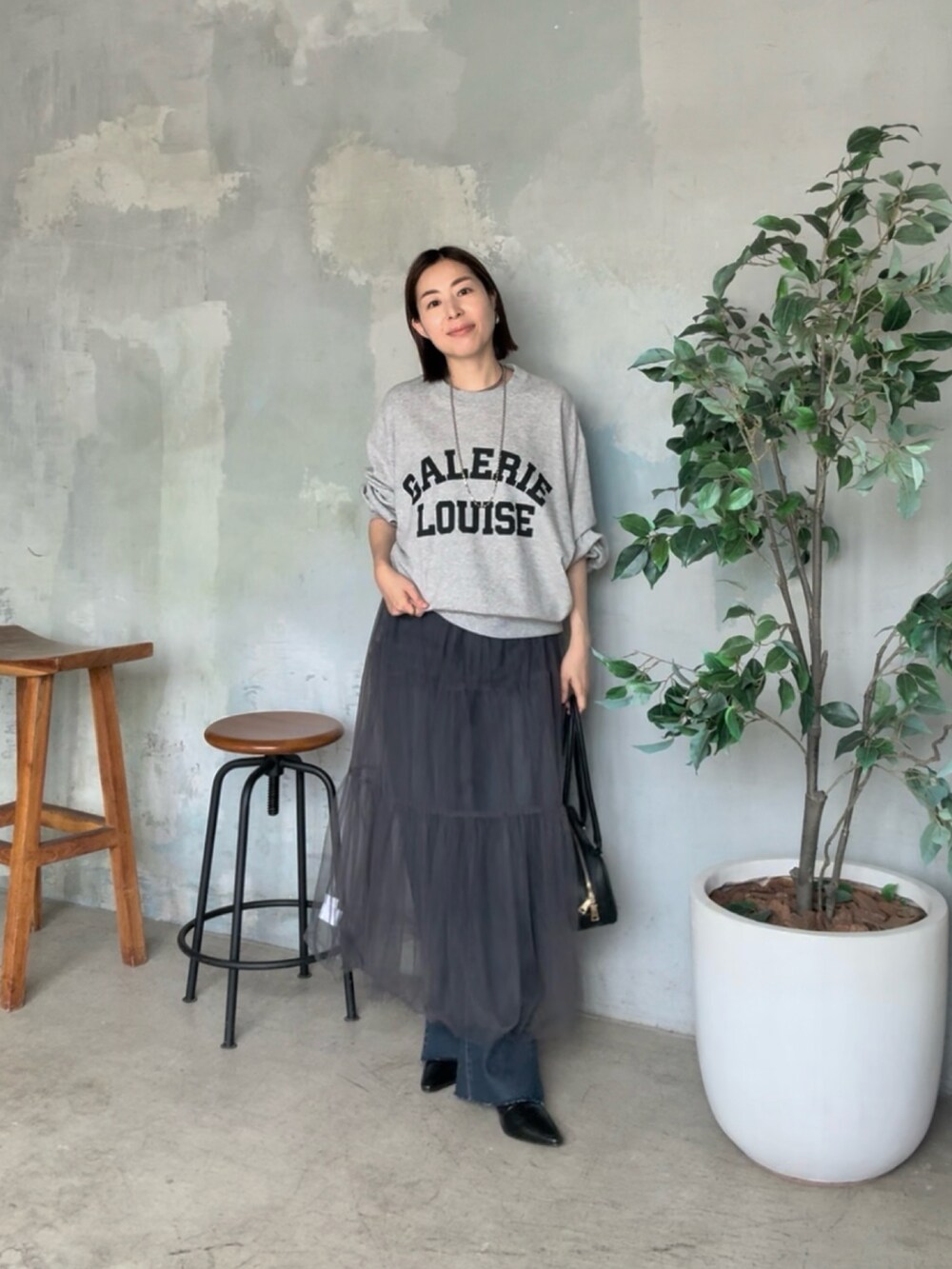 グレー系のスウェット、グレー系のスカートを着用したレディースの夏コーディネートの2枚目の写真