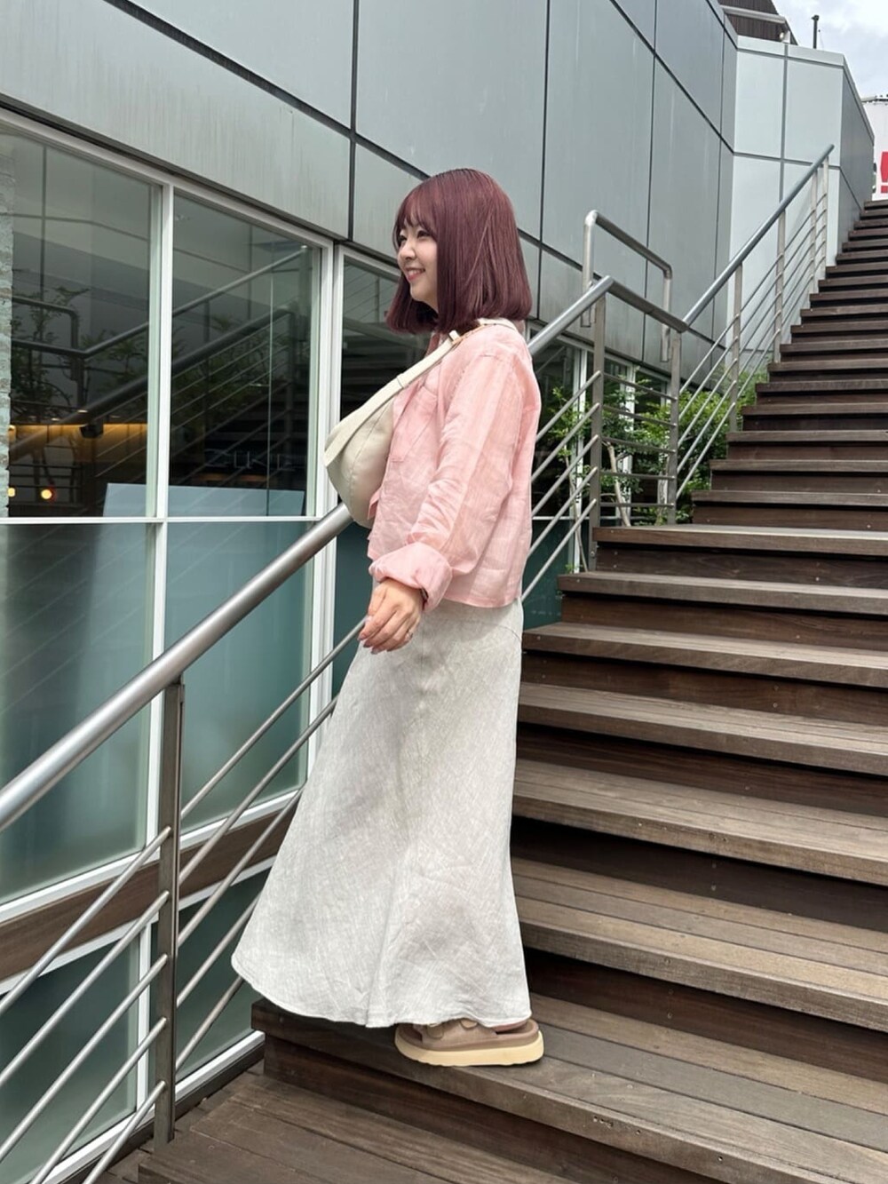 ピンク系のシャツ/ブラウス、ホワイト系のボディバッグ/ウエストポーチ、ベージュ系のスカートを着用したレディースの春コーディネートの2枚目の写真