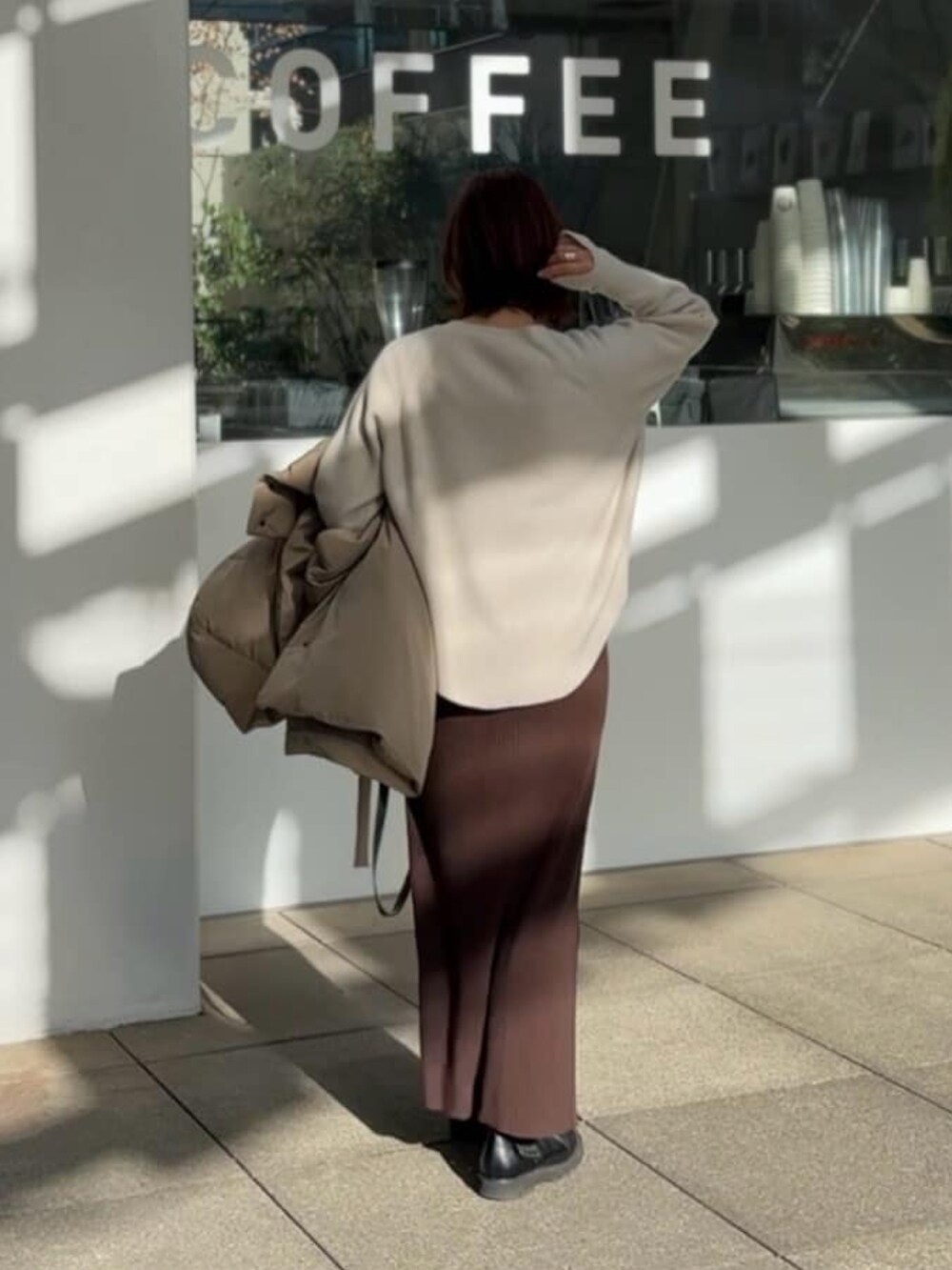 ホワイト系のニット/セーター、ブラウン系のワンピースを着用したレディースの冬コーディネートの5枚目の写真