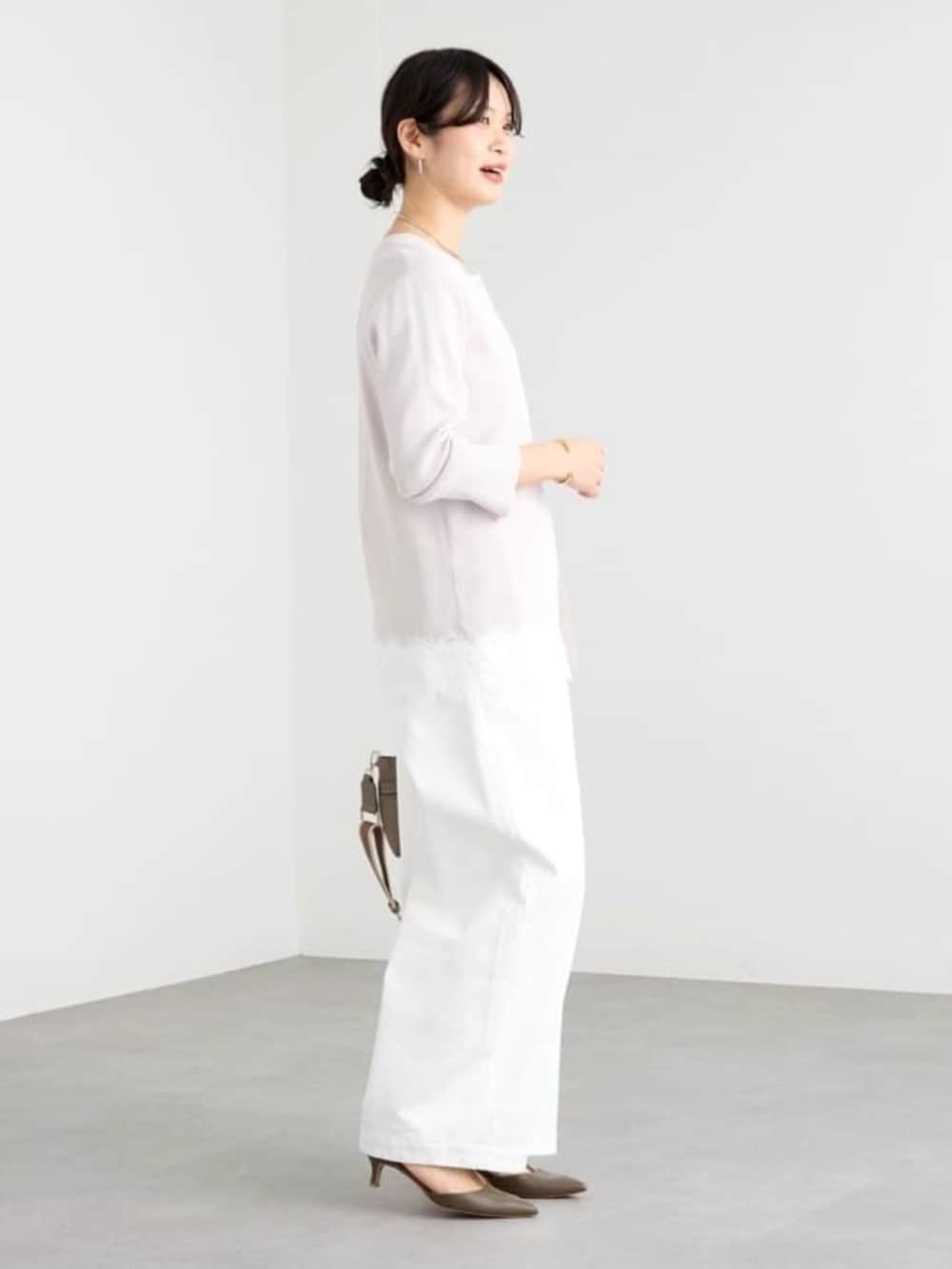 グレー系のトートバッグ、グレー系のその他シューズ、ホワイト系のデニムパンツを着用したレディースの冬コーディネートの2枚目の写真