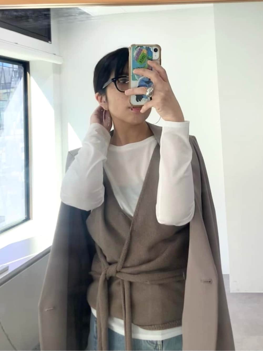 ブラウン系のテーラードジャケット、ブラック系のボストンバッグ、ブルー系のデニムパンツを着用したレディースの冬コーディネートの2枚目の写真