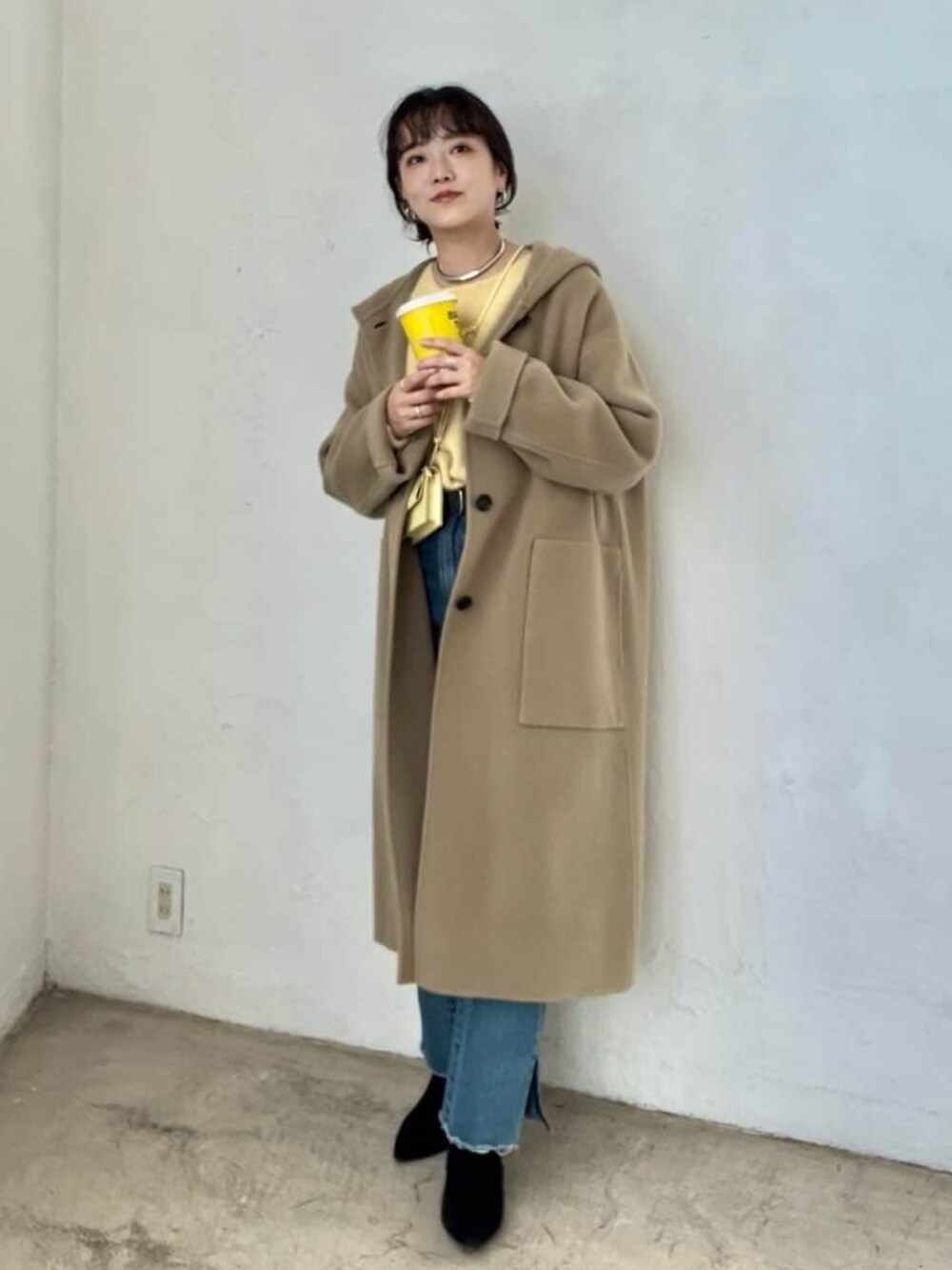 グリーン系のその他アウター、ブルー系のデニムパンツ、ブラック系のブーツを着用したレディースの冬コーディネートの2枚目の写真