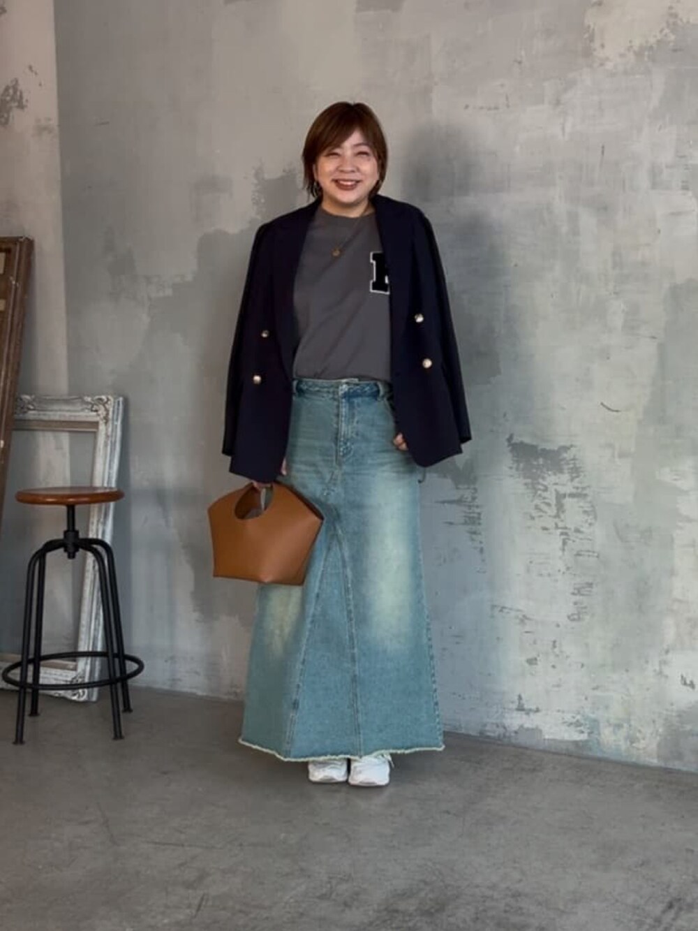 ブルー系のテーラードジャケット、グレー系のTシャツ/カットソー、ブルー系のデニムスカートを着用したレディースの冬コーディネートの2枚目の写真