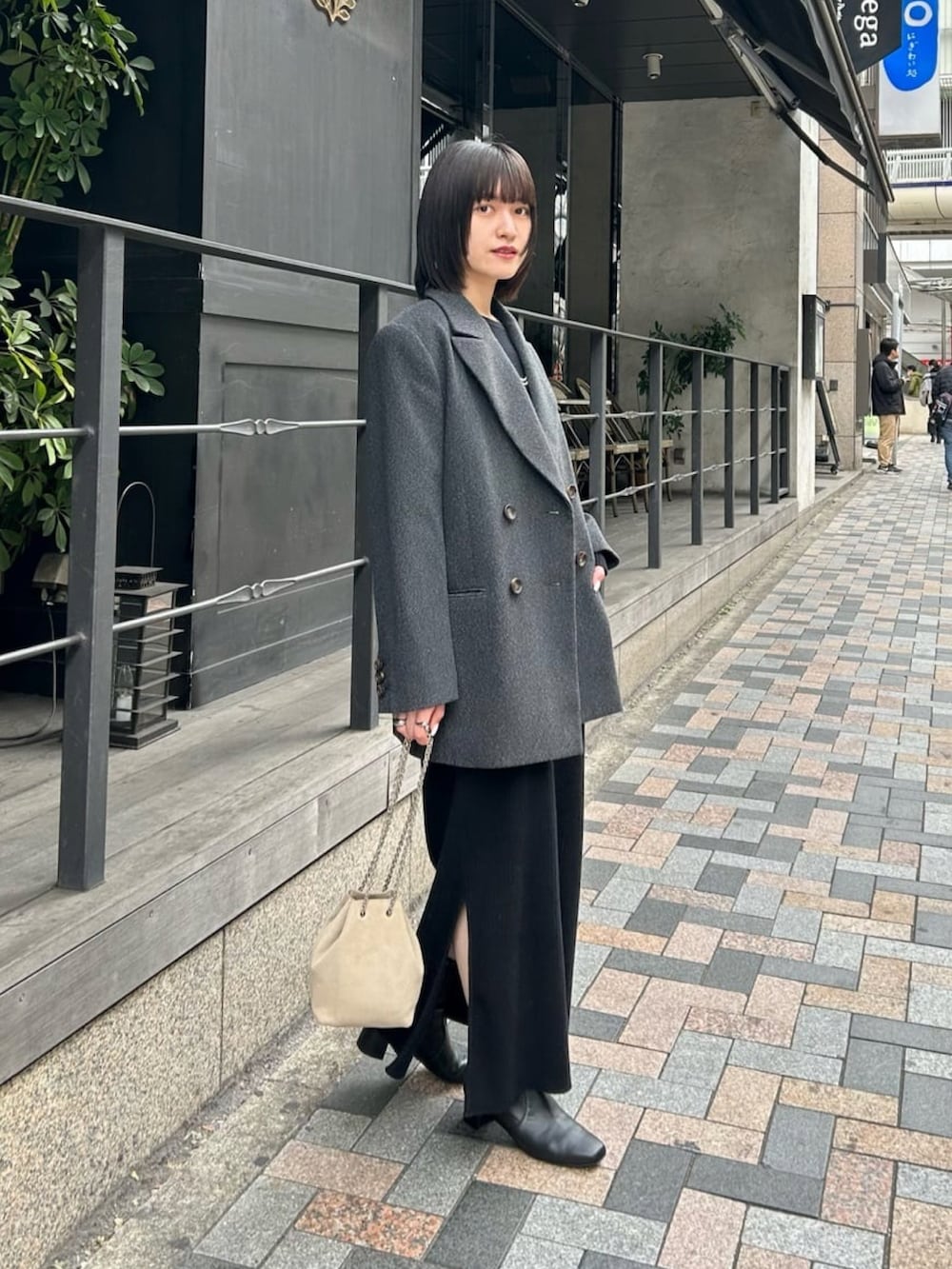 グレー系のその他アウター、ブラック系のワンピース、ブラック系のブーツを着用したレディースの冬コーディネートの2枚目の写真