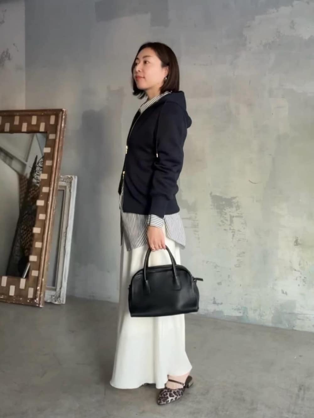 ブルー系のパーカー、ホワイト系のシャツ/ブラウス、ブラック系のボストンバッグを着用したレディースの冬コーディネートの2枚目の写真