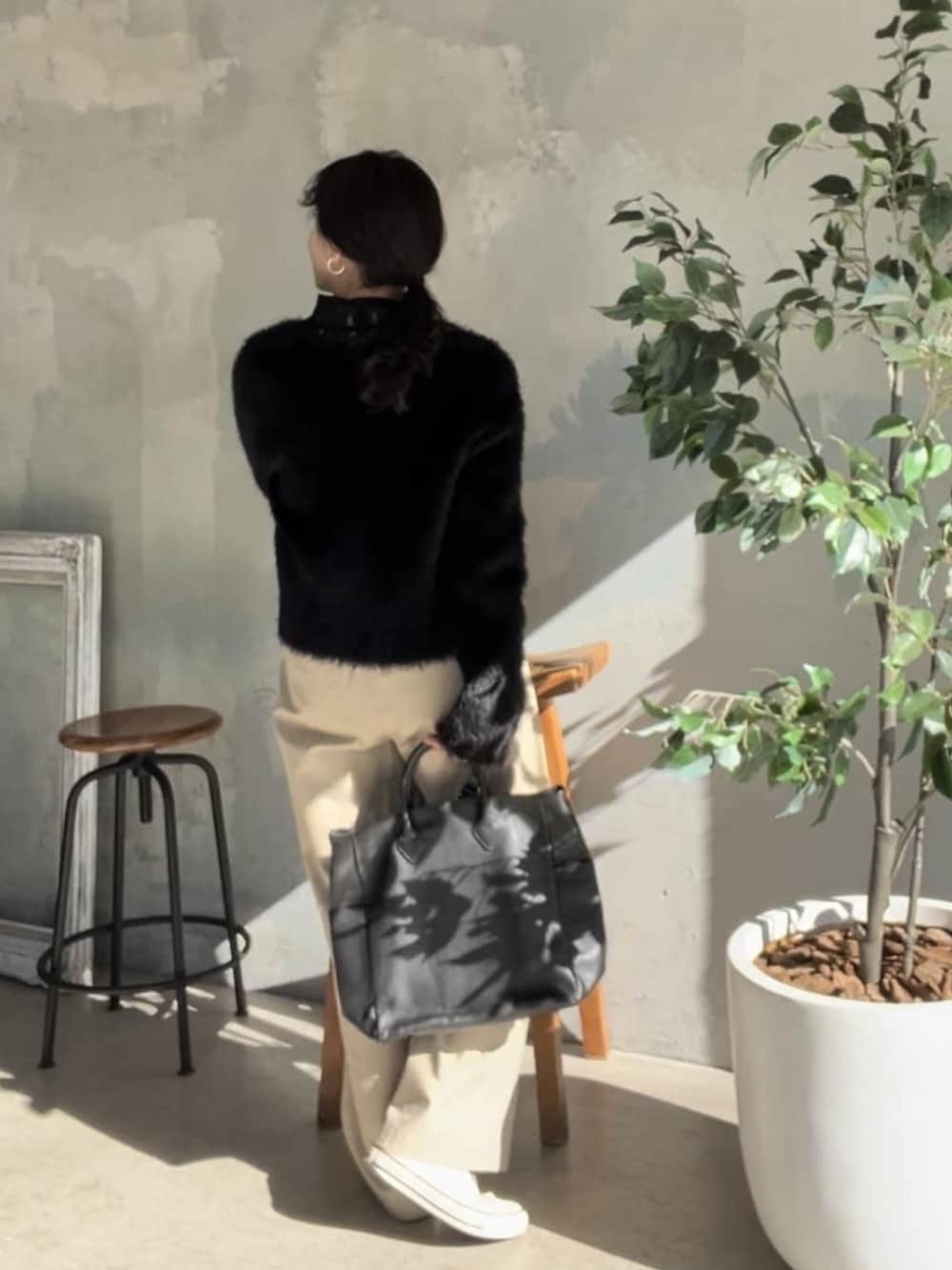 ブラック系のTシャツ/カットソー、ブラック系のトートバッグ、シルバー系のネックレスを着用したレディースの冬コーディネートの2枚目の写真