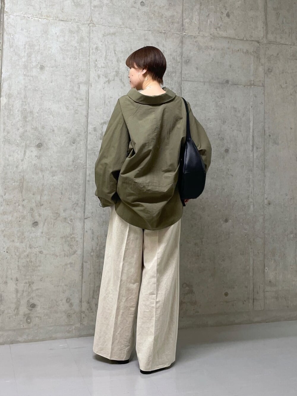 ブラック系のボディバッグ/ウエストポーチ、グリーン系のシャツ/ブラウス、ベージュ系のその他パンツを着用したレディースの春コーディネートの4枚目の写真