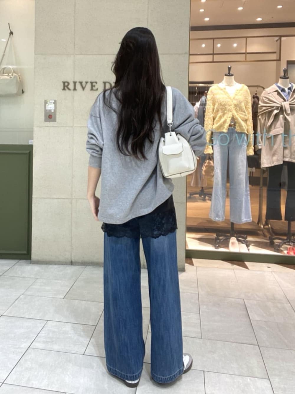 グレー系のスウェット、ブラウン系のキャミソール、ホワイト系のショルダーバッグを着用したレディースの春コーディネートの3枚目の写真