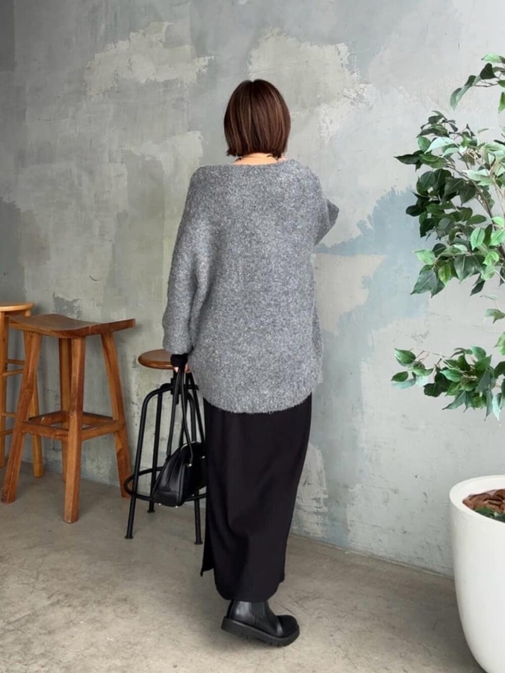グレー系のニット/セーター、ブラック系のワンピース、ブラック系のショルダーバッグを着用したレディースの秋コーディネートの3枚目の写真