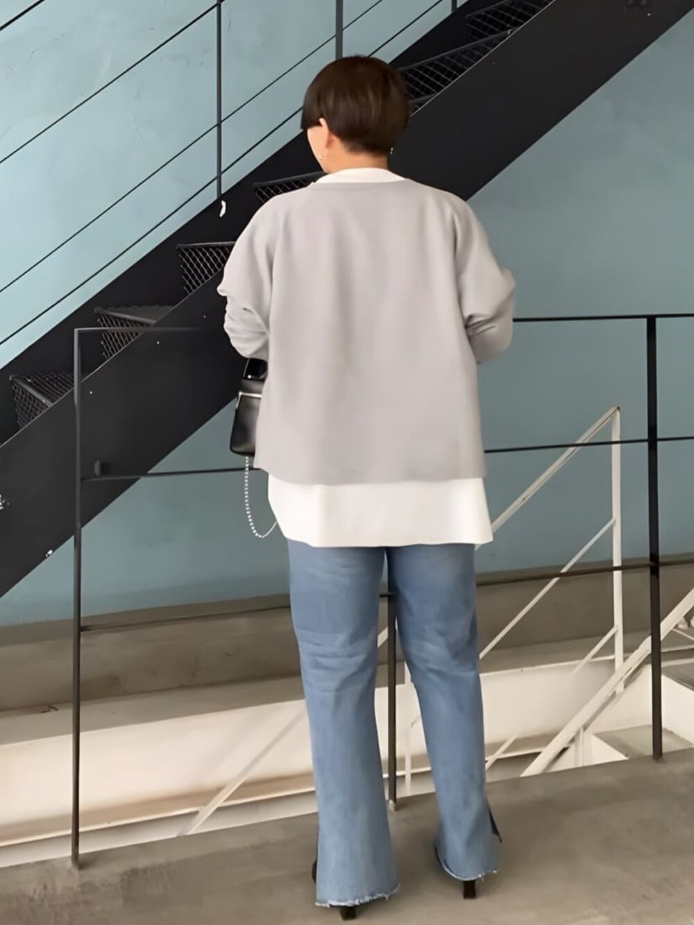 グレー系のスウェット、ホワイト系のTシャツ/カットソー、ブラック系のハンドバッグを着用したレディースの秋コーディネートの2枚目の写真