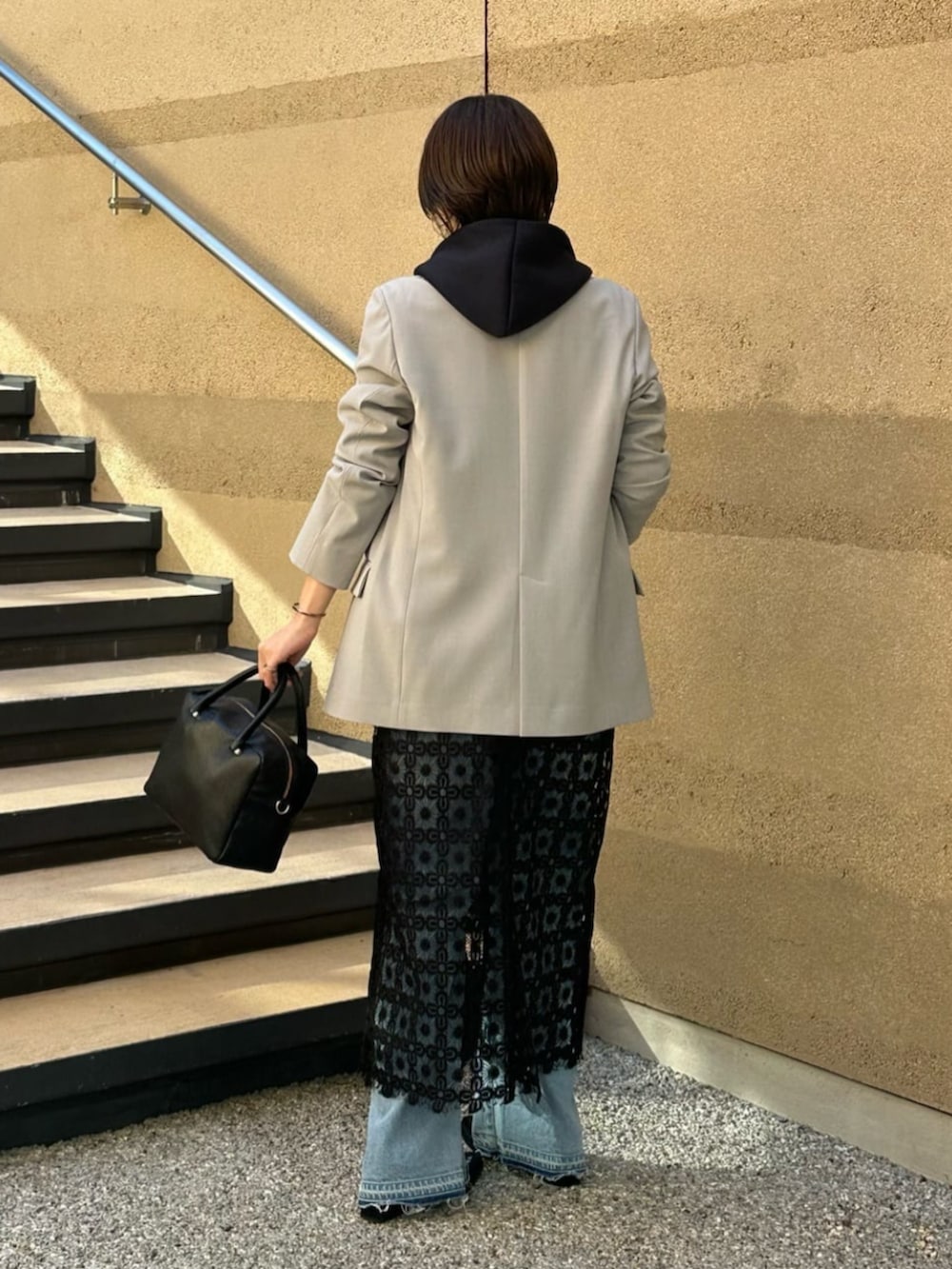 ブルー系のパーカー、ブラック系のボストンバッグ、ブルー系のデニムパンツを着用したレディースの冬コーディネートの4枚目の写真