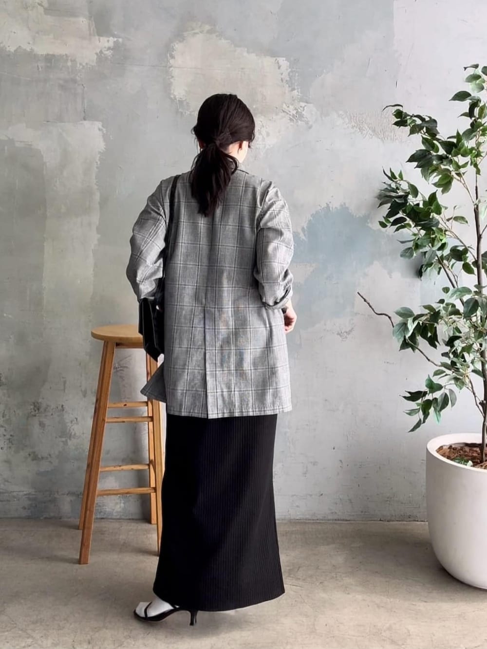 グレー系のテーラードジャケット、ブラック系のワンピース、ブラック系のサンダルを着用したレディースの春コーディネートの3枚目の写真