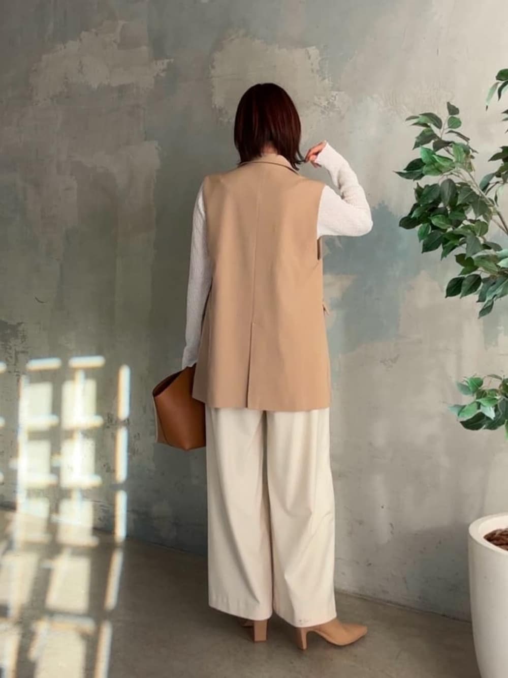 ホワイト系のTシャツ/カットソー、ベージュ系のベスト、イエロー系のハンドバッグを着用したレディースの冬コーディネートの3枚目の写真