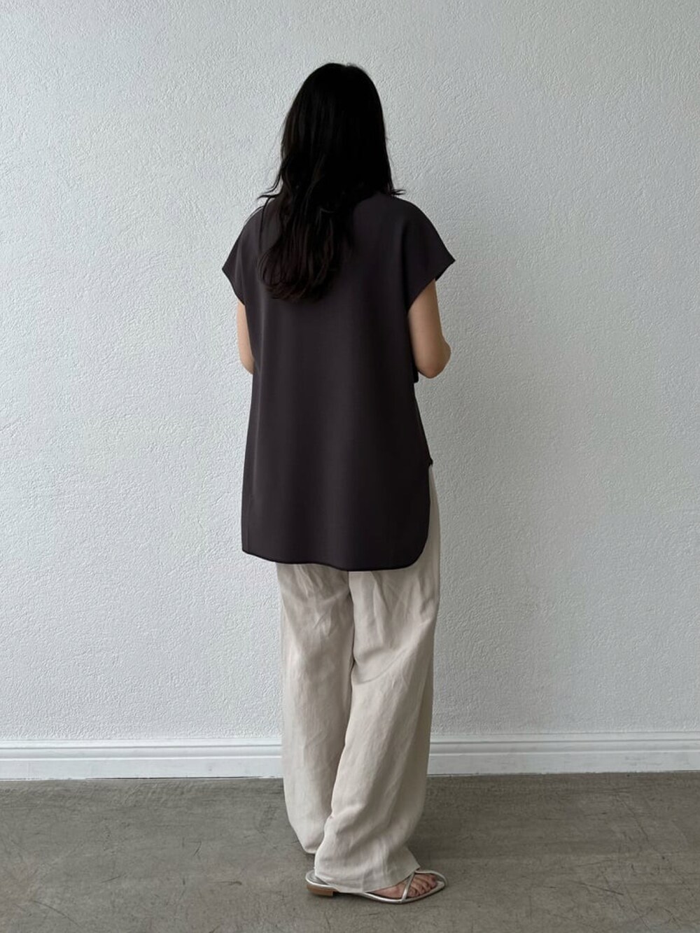 ベージュ系のパンツ、ゴールド系のショルダーバッグ、ブラック系のサンダルを着用したレディースの春コーディネートの3枚目の写真