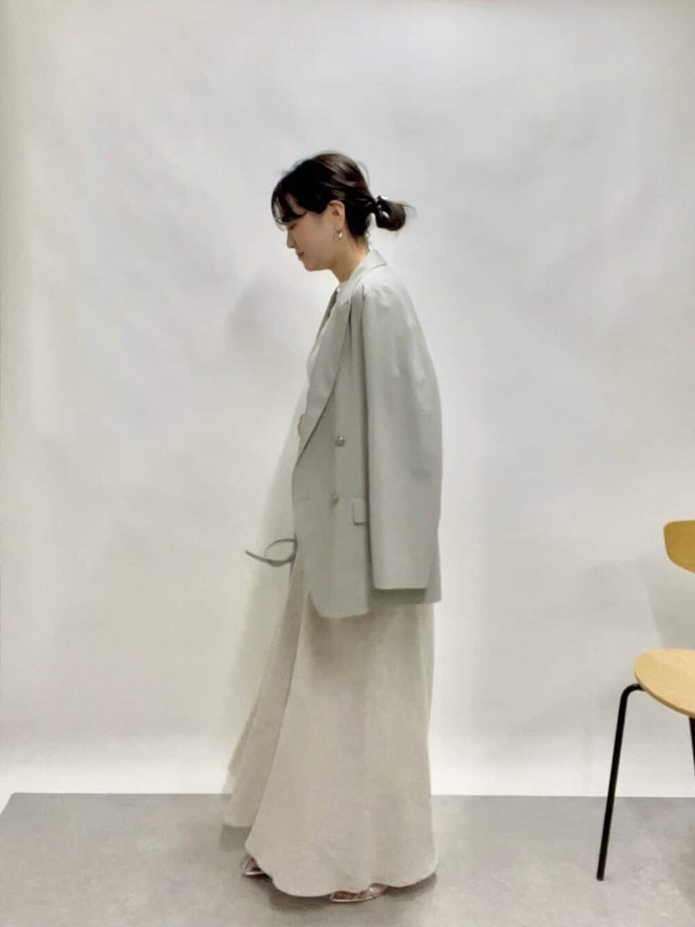 ベージュ系のテーラードジャケット、グリーン系のスカート、ブルー系のショルダーバッグを着用したレディースの春コーディネートの2枚目の写真