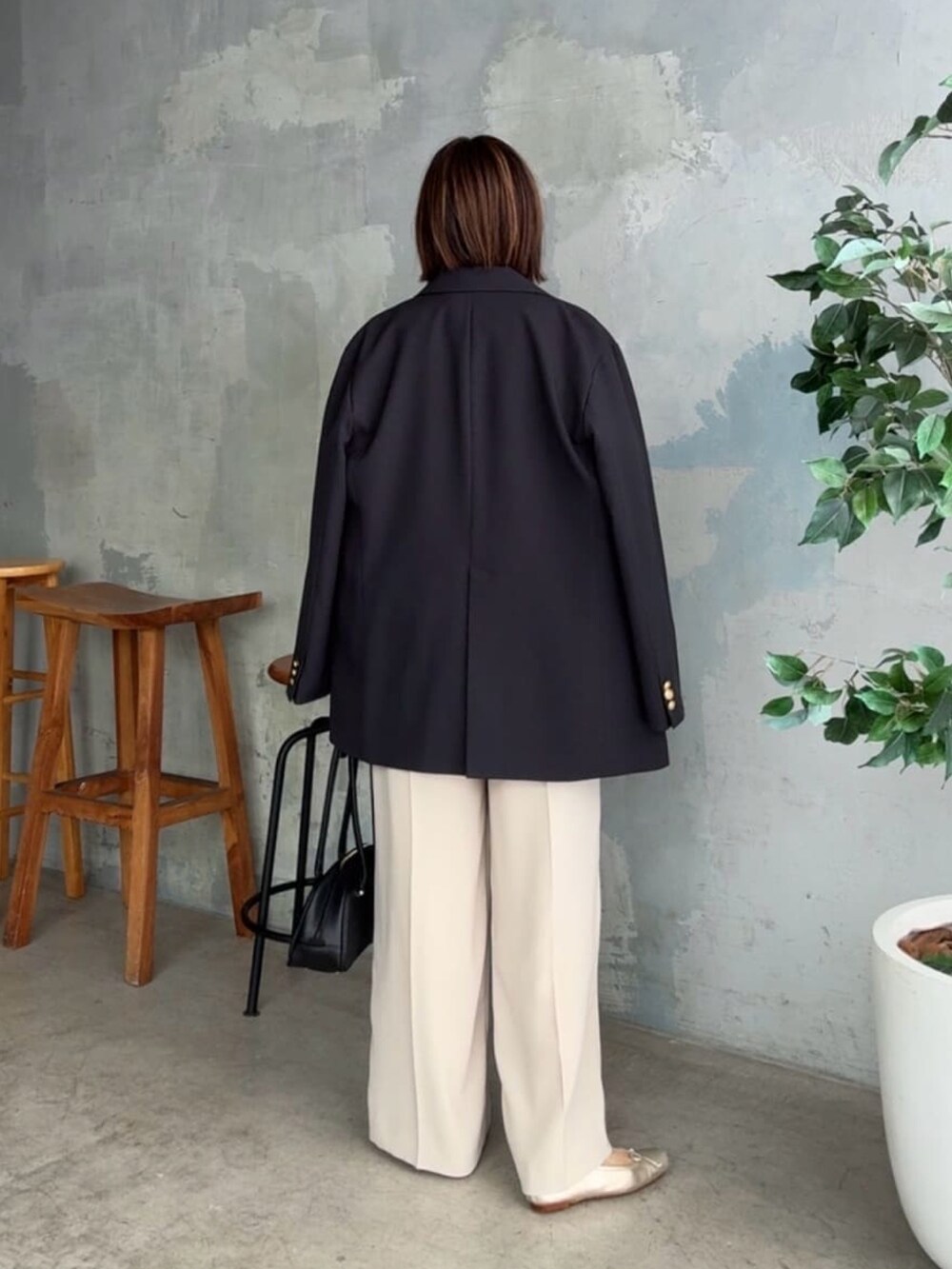 ブルー系のニット/セーター、ブルー系のテーラードジャケット、ベージュ系のその他パンツを着用したレディースの秋コーディネートの4枚目の写真