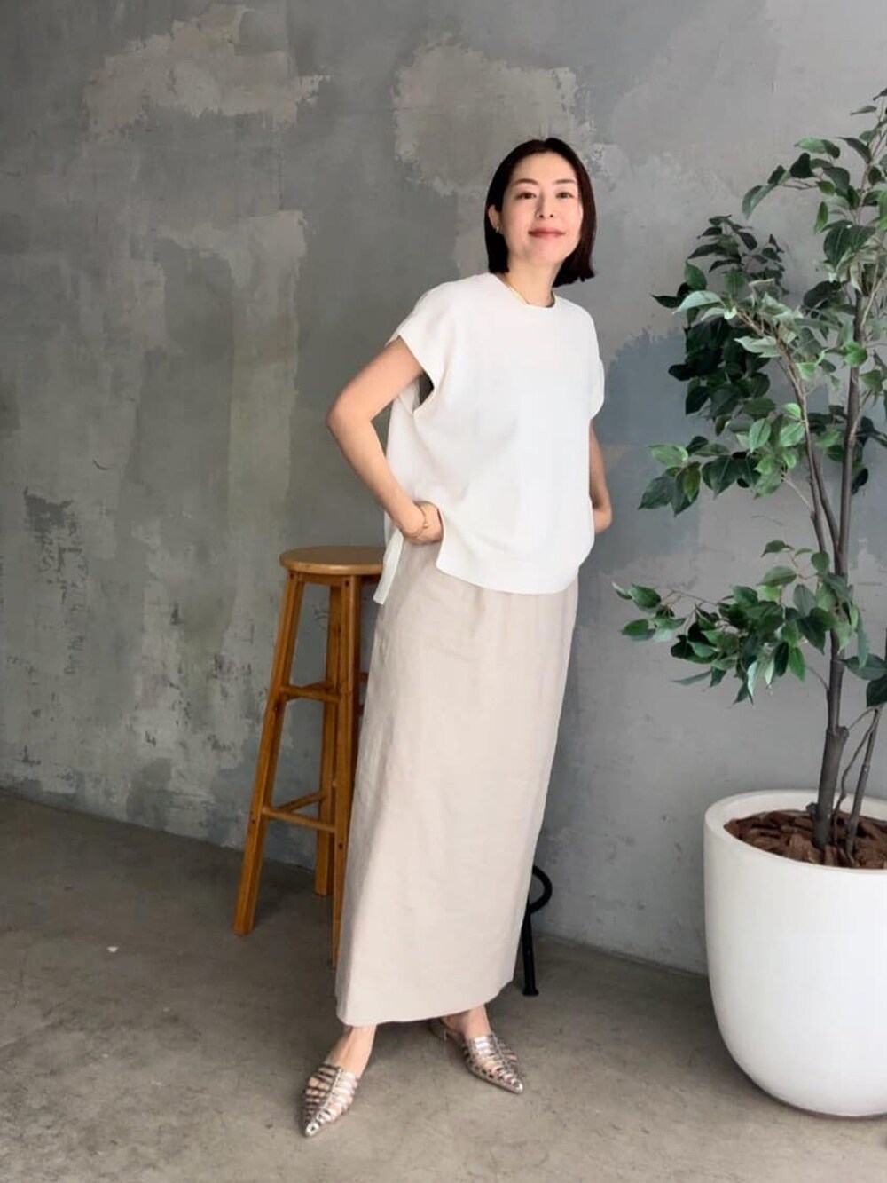 ブラック系のテーラードジャケット、ホワイト系のニット/セーター、ベージュ系のスカートを着用したレディースの春コーディネートの4枚目の写真