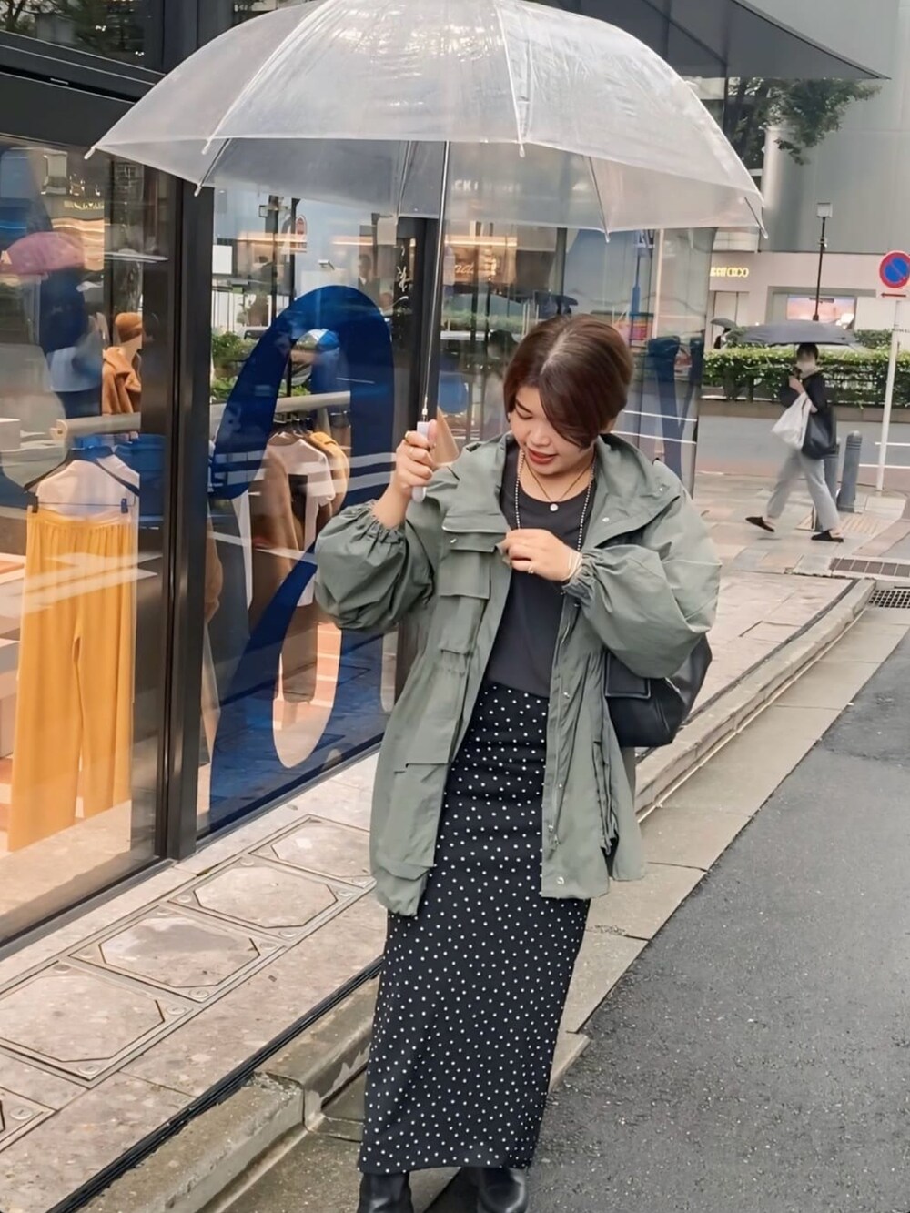 グリーン系のマウンテンパーカー、ブラック系のシャツ/ブラウス、ブラック系のスカートを着用したレディースの秋コーディネートの4枚目の写真