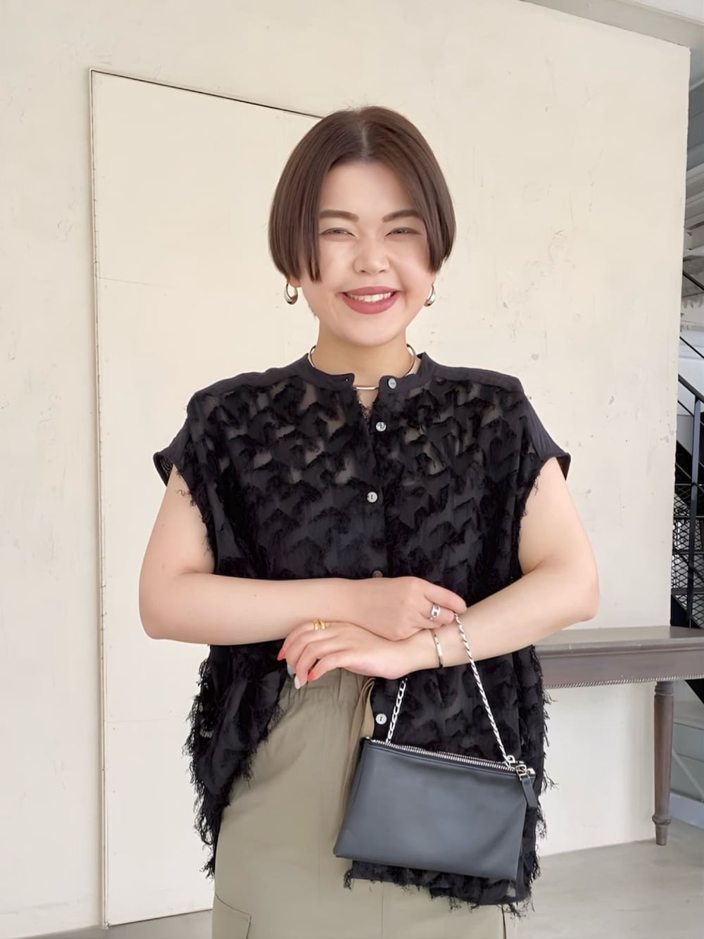 ブラック系のシャツ/ブラウス、ブラック系のショルダーバッグ、グリーン系のスカートを着用したレディースの夏コーディネートの5枚目の写真