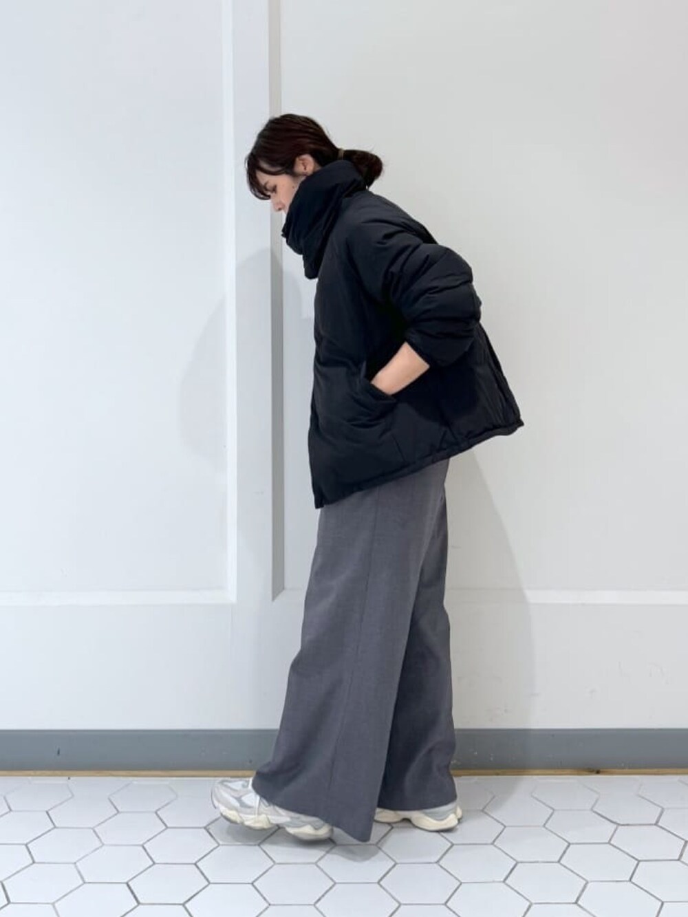 ブラック系のダウンジャケット/コート、グレー系のニット/セーター、グレー系のその他パンツを着用したレディースの冬コーディネートの3枚目の写真