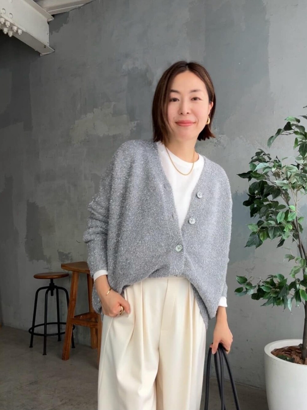 グレー系のカーディガン/ボレロ、ホワイト系のスラックス、ホワイト系のシャツ/ブラウスを着用したレディースの秋コーディネートの4枚目の写真