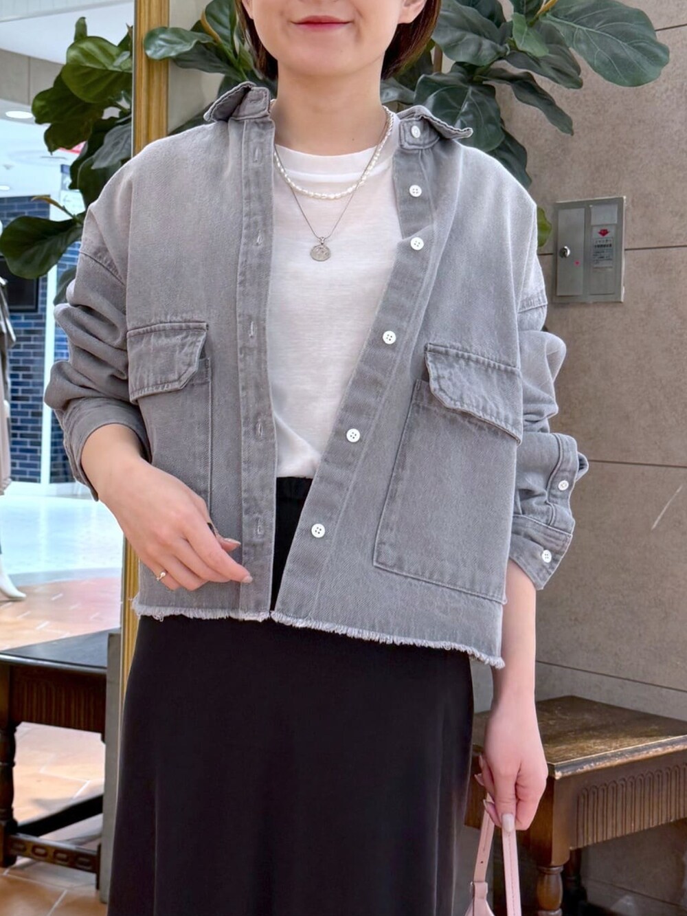 ホワイト系のTシャツ/カットソー、グレー系のシャツ/ブラウス、ピンク系のハンドバッグを着用したレディースの冬コーディネートの4枚目の写真