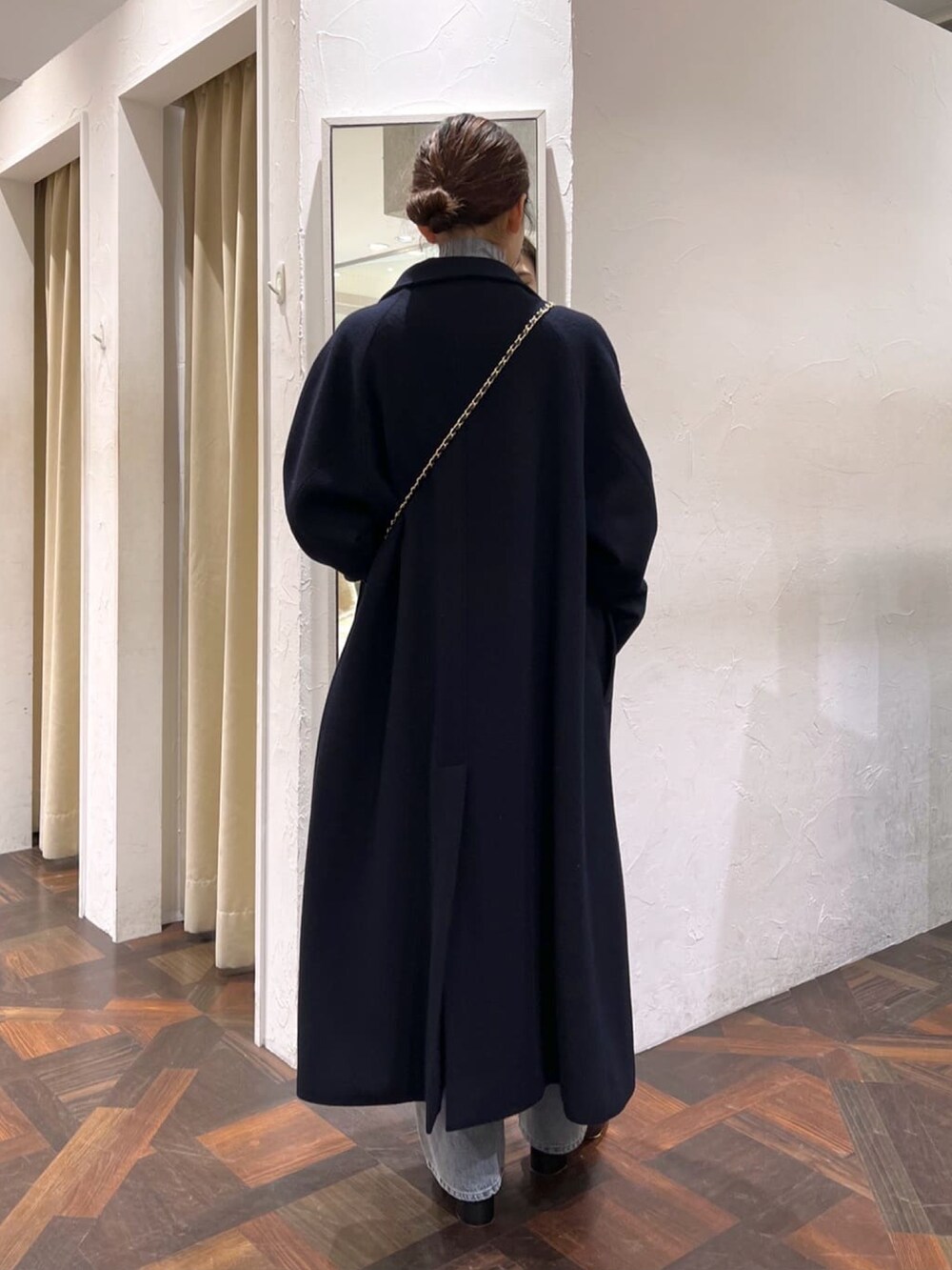 ブラック系のハンドバッグ、ブルー系のその他アウター、グレー系のニット/セーターを着用したレディースの冬コーディネートの4枚目の写真