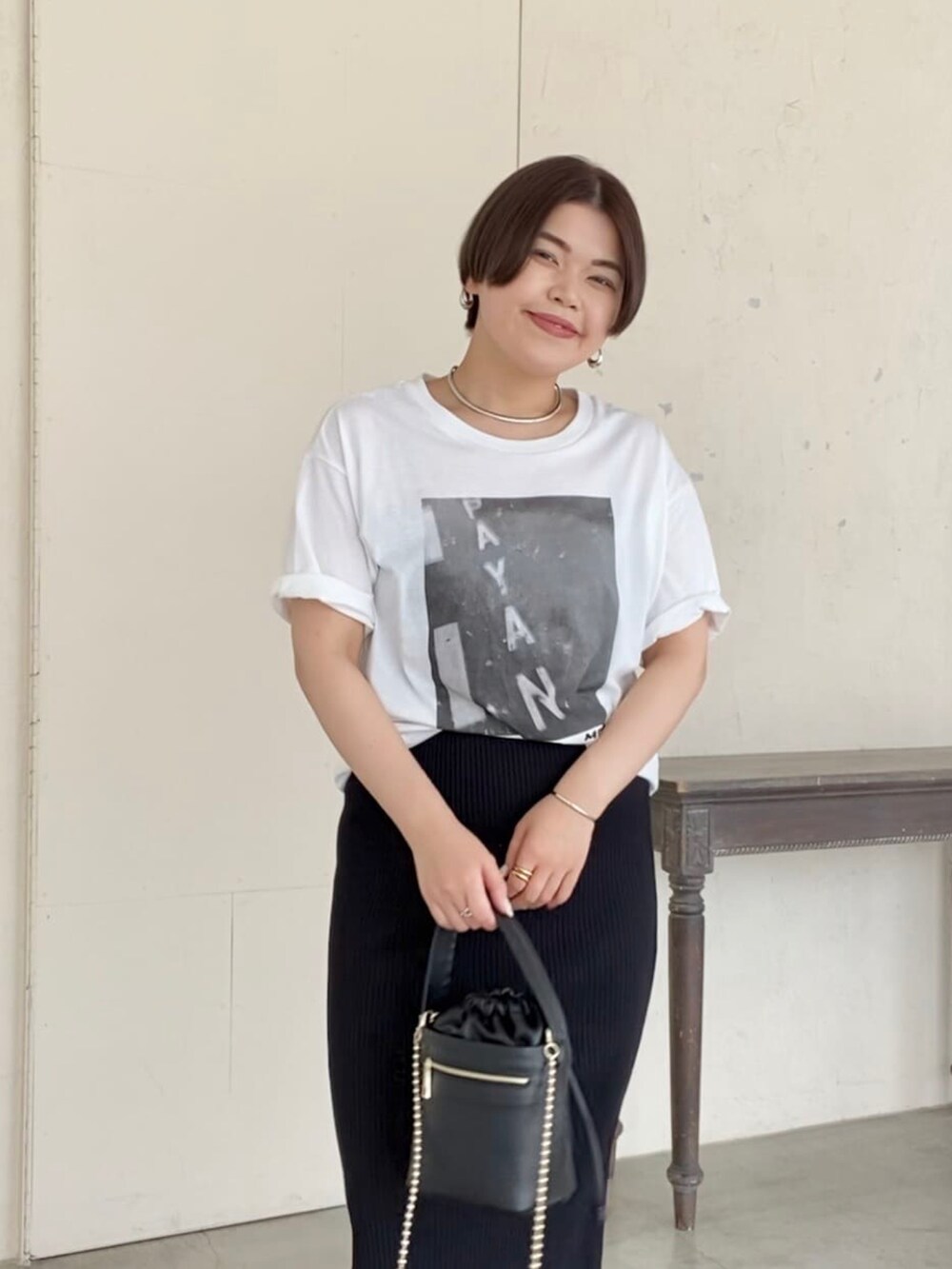 ブラック系のTシャツ/カットソー、ブラック系のスカート、ブラック系のサンダルを着用したレディースの夏コーディネートの3枚目の写真