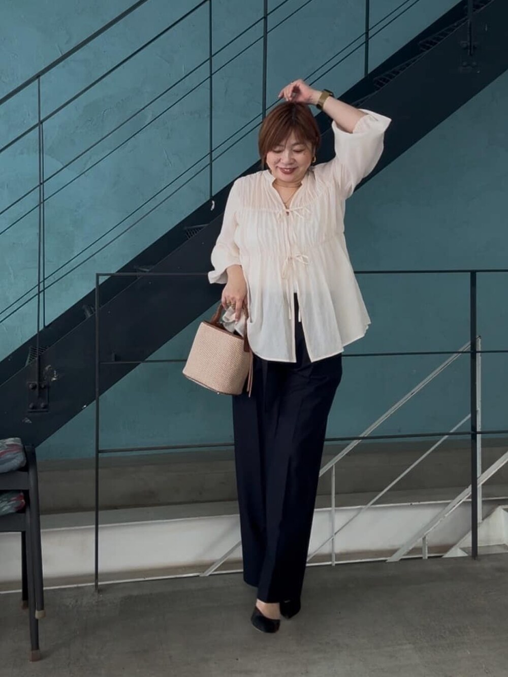 ホワイト系のシャツ/ブラウス、ブラウン系のハンドバッグ、ブルー系のチノパンツを着用したレディースの春コーディネートの3枚目の写真