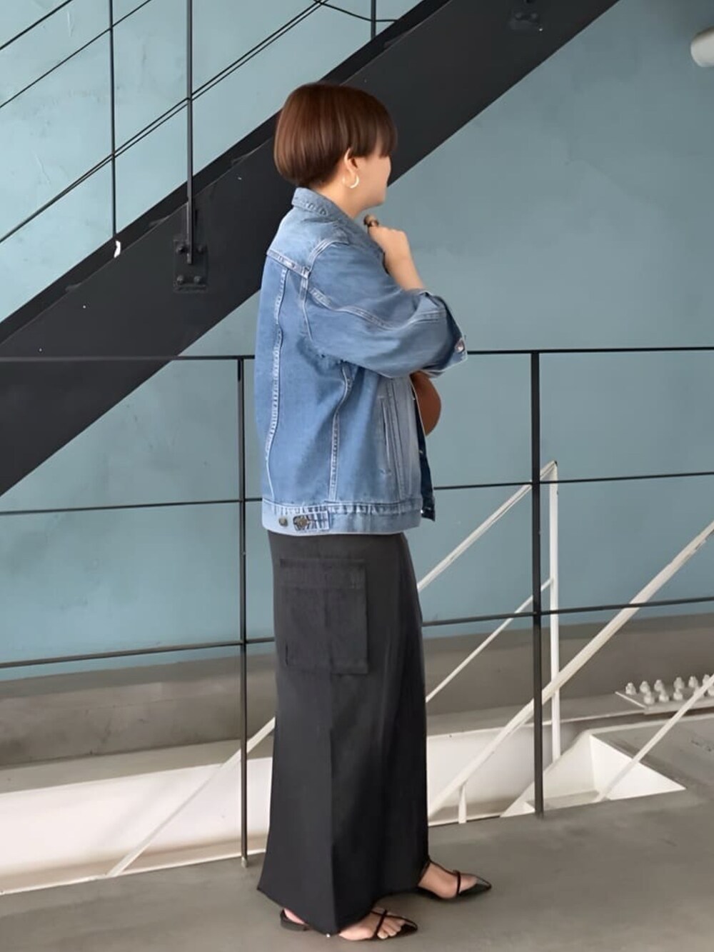 ブルー系のデニムスカート、ブルー系のデニムジャケットを着用したレディースの春コーディネートの3枚目の写真