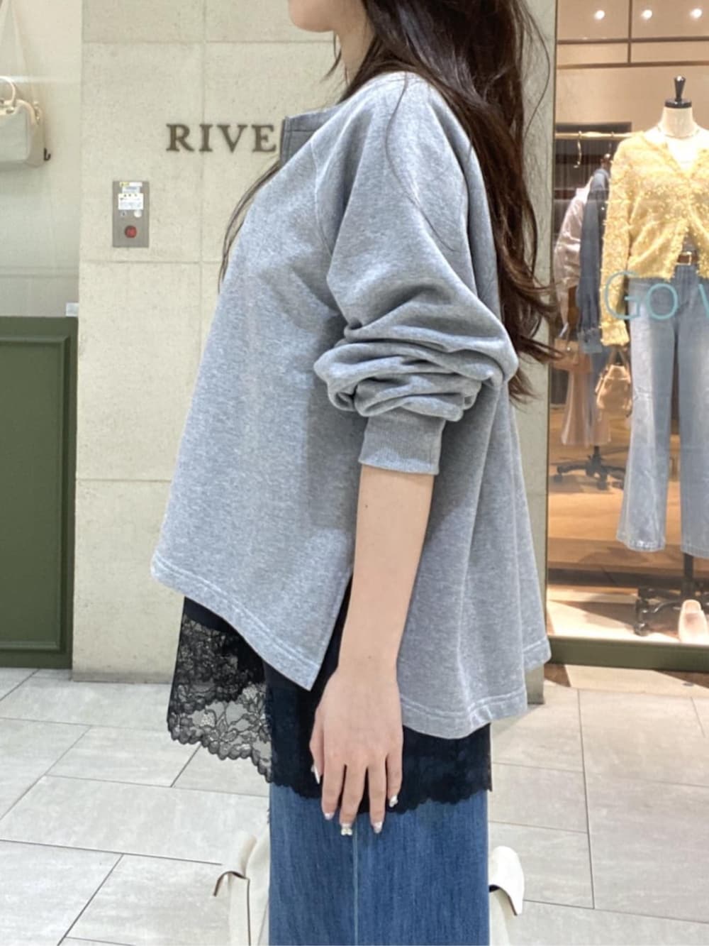 グレー系のスウェット、ブラウン系のキャミソール、ホワイト系のショルダーバッグを着用したレディースの春コーディネートの5枚目の写真