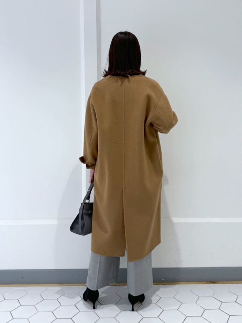 ブラック系のニット/セーター、グレー系のその他パンツ、ブラック系のブーツを着用したレディースの冬コーディネートの4枚目の写真