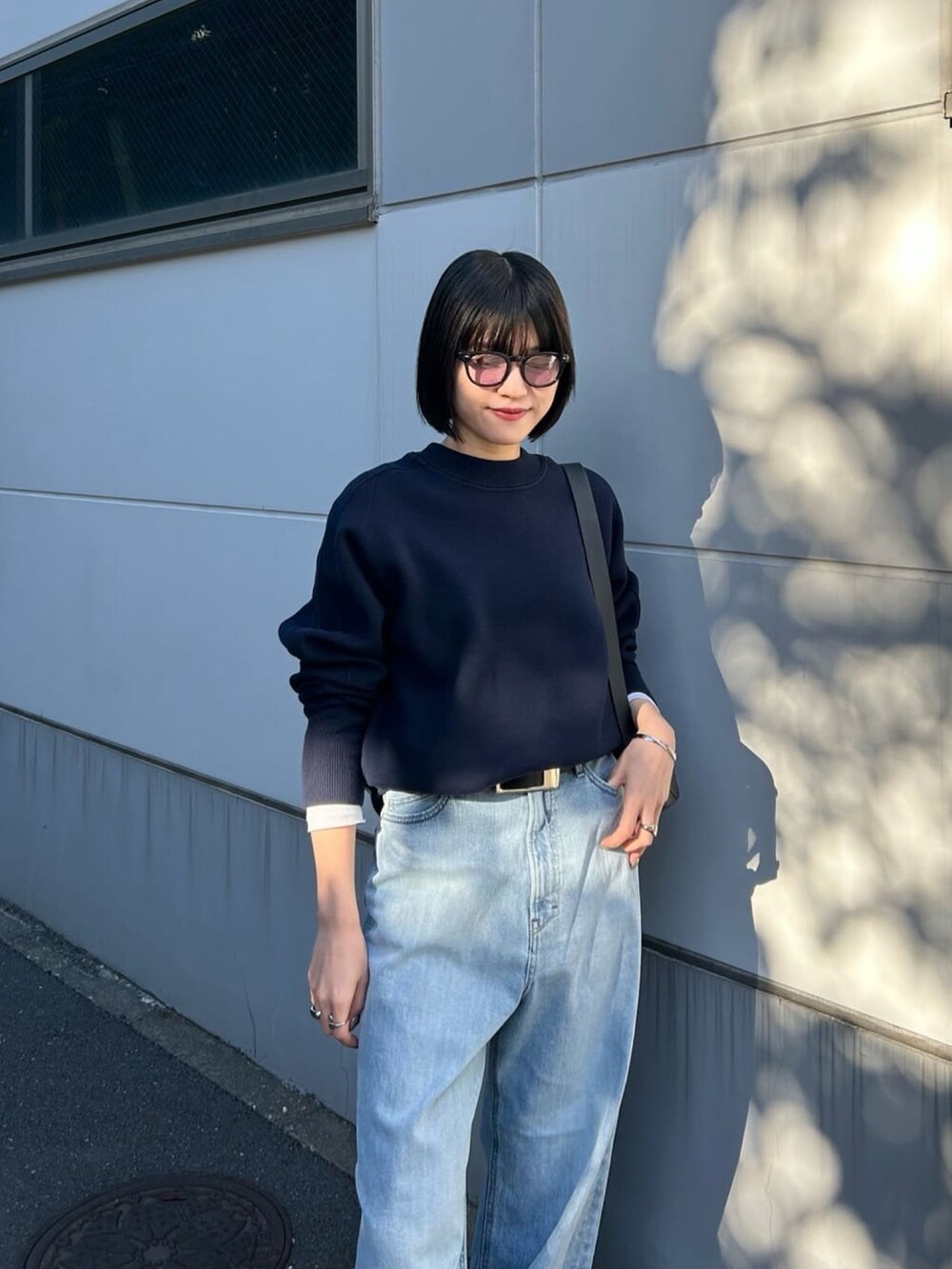 ブルー系のニット/セーター、ホワイト系のTシャツ/カットソー、ブラック系のボディバッグ/ウエストポーチを着用したレディースの春コーディネートの3枚目の写真