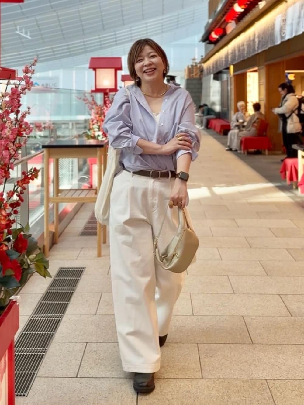 グレー系のトートバッグ、ホワイト系のデニムパンツ、ブラック系のその他シューズを着用したレディースの春コーディネートの4枚目の写真