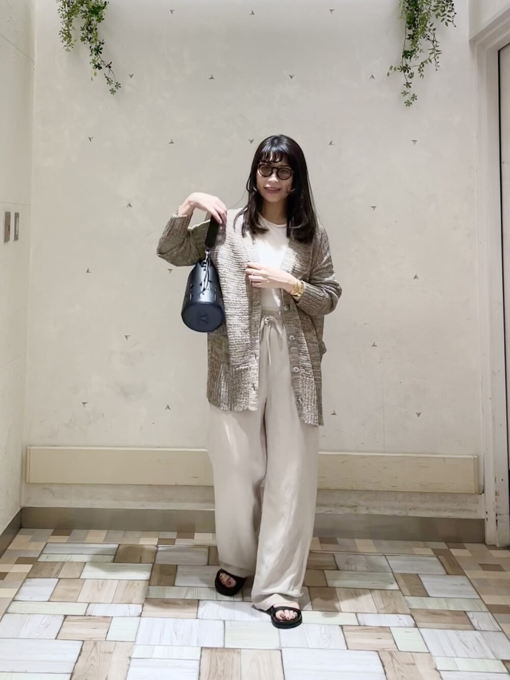 ブラウン系のカーディガン/ボレロ、ベージュ系のパンツ、ホワイト系のTシャツ/カットソーを着用したレディースの春コーディネートの2枚目の写真