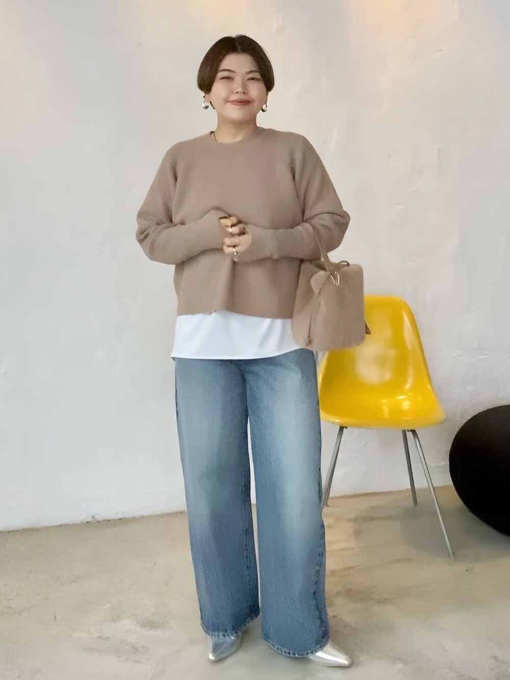 ブラウン系のニット/セーター、ブルー系のデニムパンツ、ホワイト系のシャツ/ブラウスを着用したレディースの秋コーディネートの3枚目の写真