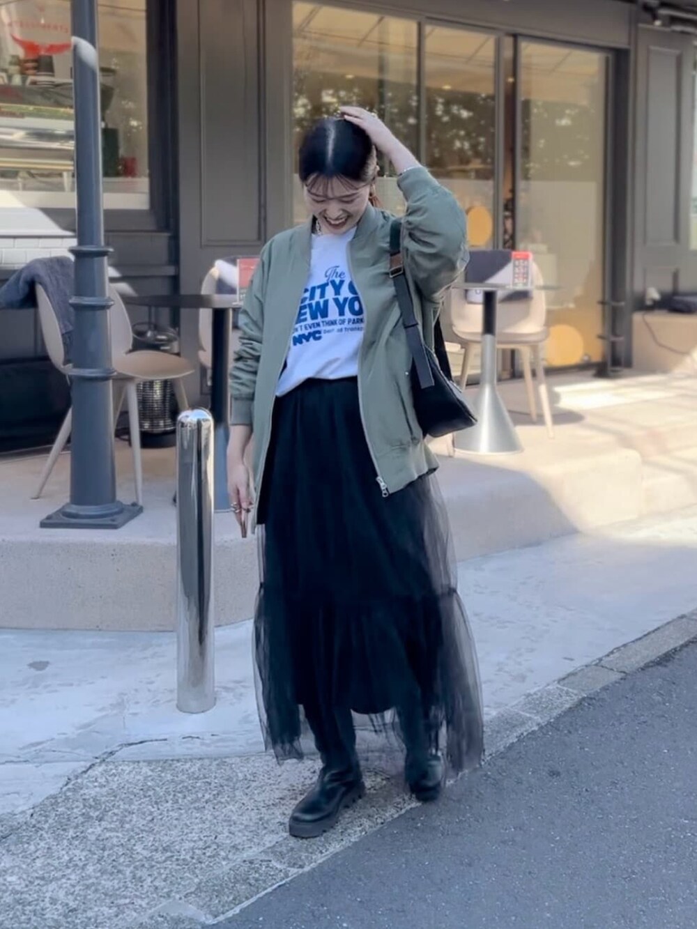 ブラック系のスカート、ブラック系のボディバッグ/ウエストポーチを着用したレディースの冬コーディネートの2枚目の写真