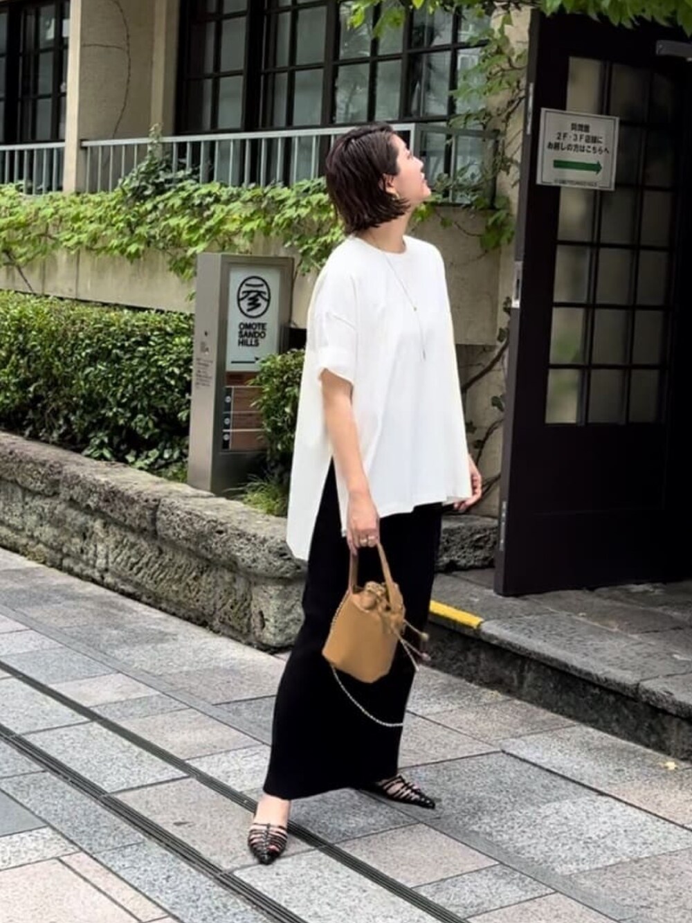 ホワイト系のTシャツ/カットソー、ブラック系のスカートを着用したレディースの春コーディネートの2枚目の写真