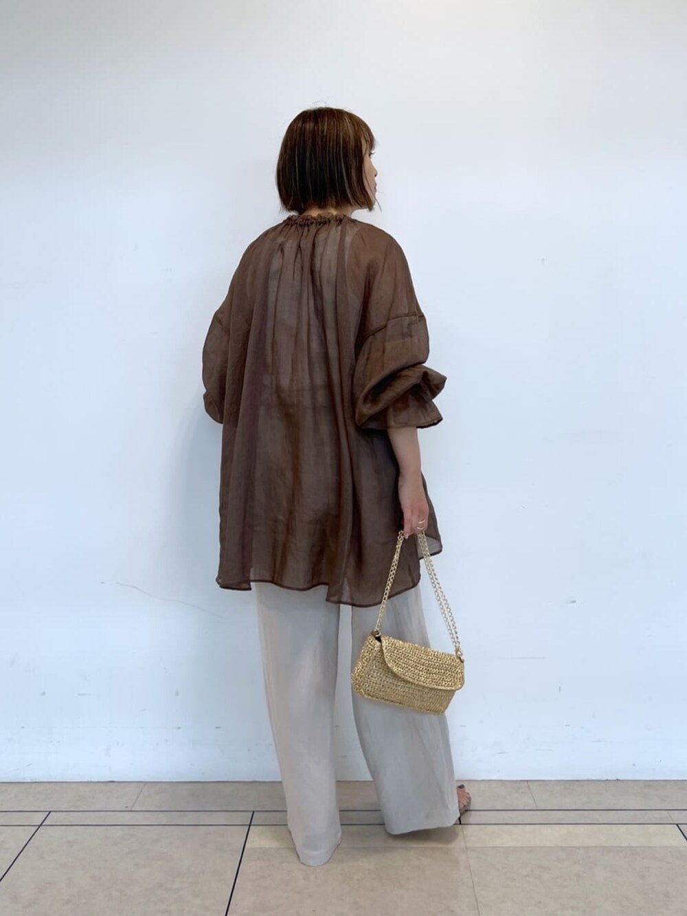 ブラウン系のシャツ/ブラウス、ベージュ系のパンツ、ゴールド系のショルダーバッグを着用したレディースの春コーディネートの3枚目の写真