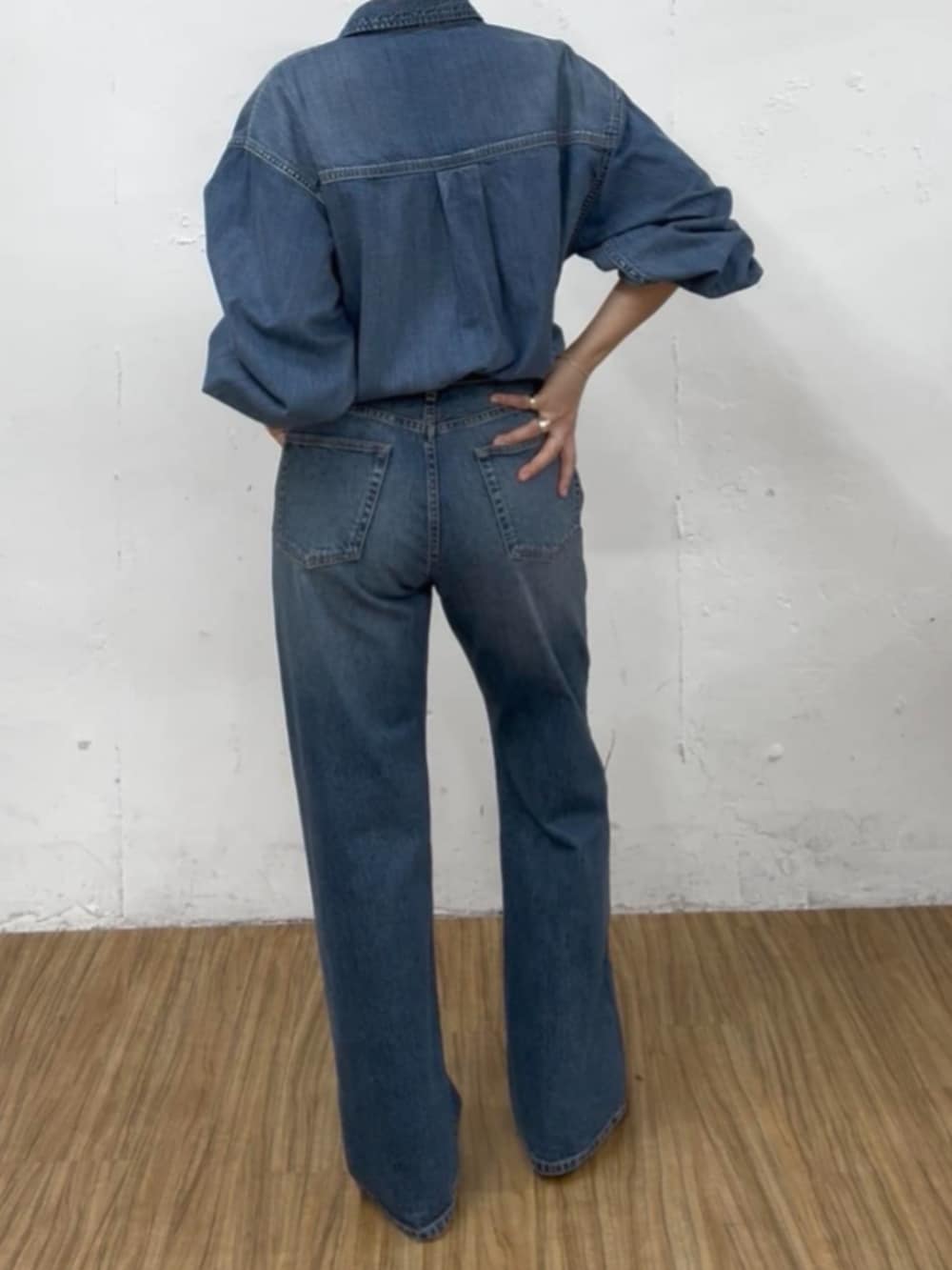 レッド系のパンプス、ブルー系のデニムパンツ、ブラウン系のベルトを着用したレディースの夏コーディネートの2枚目の写真