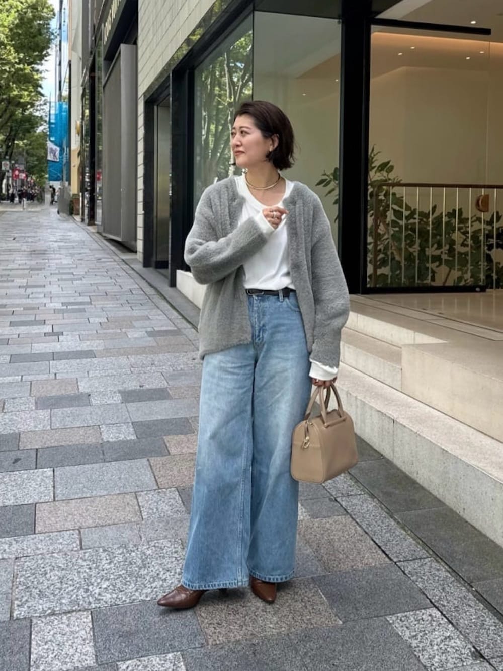 グレー系のカーディガン/ボレロ、ブルー系のデニムパンツ、ホワイト系のTシャツ/カットソーを着用したレディースの秋コーディネートの2枚目の写真