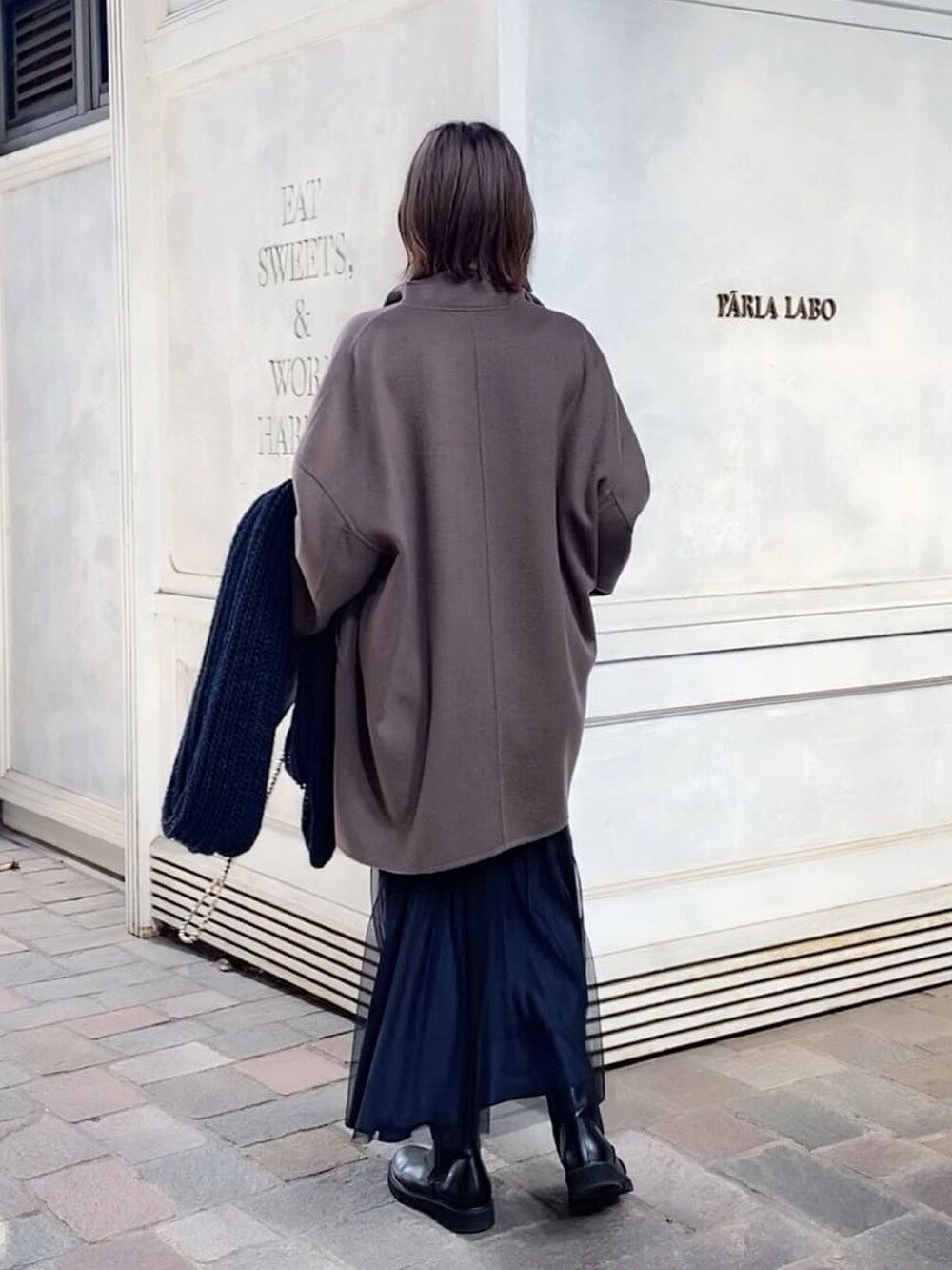 ブラウン系のその他アウター、ブラック系のスカート、ブラック系のハンドバッグを着用したレディースの秋コーディネートの3枚目の写真