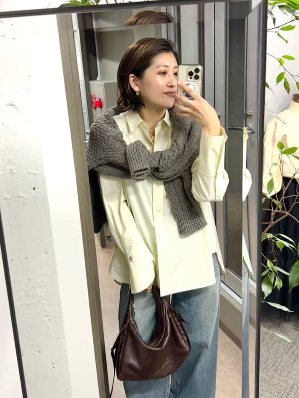 ブラウン系のショルダーバッグ、ホワイト系のシャツ/ブラウス、ブラウン系のローファーを着用したレディースの秋コーディネートの2枚目の写真